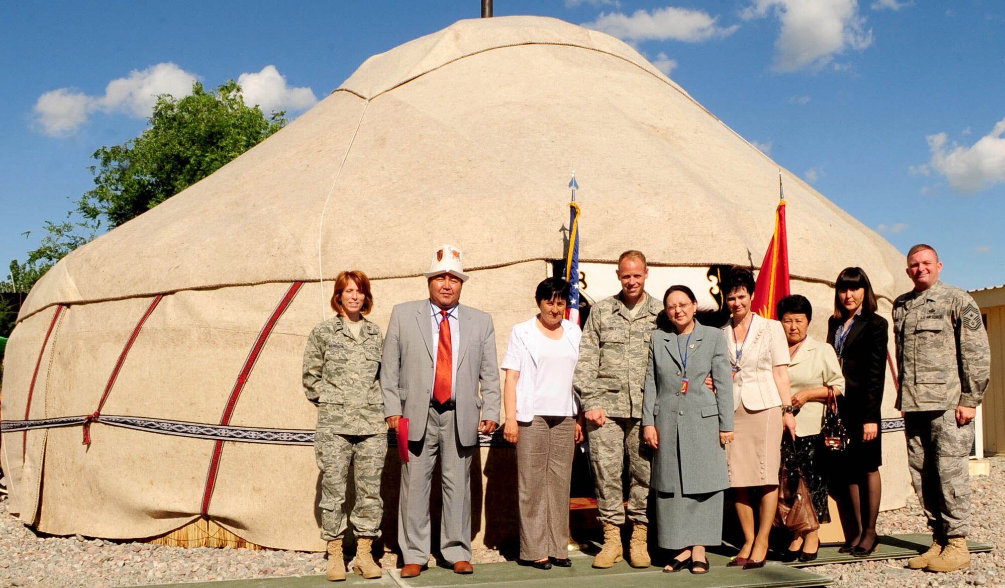 Col. Blaine Holt, Director of the Transit Center at Manas, Kyrgyzstan, along with Airmen and community leaders pose for a group photo during the grand opening of a newly-constructed Yurt at the Transit Center at Manas, Kyrgyzstan, May 28, 2010. Airmen embraced the "spirit of Kyrgyzstan" by celebrating the most recent building here: a Yurt, which is the traditional nomadic Kyrgyz home and a structure which now symbolizes the friendship between the United States and its host nation here. (U.S. Air Force photo/ Senior Airman Nichelle Anderson/ released)