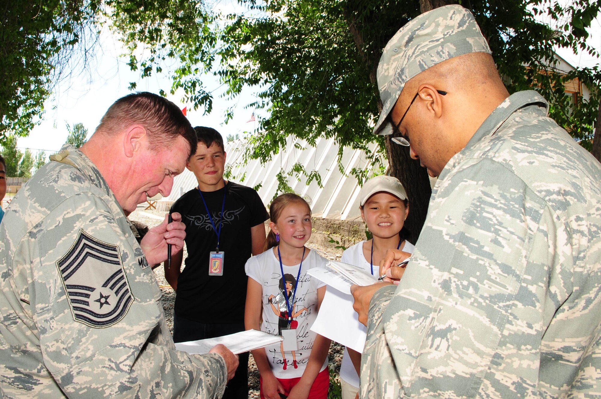 Chief Master Sgt. George McDonald, 376th Expeditionary Logistics Readiness Squadron superintendent, and Maj. James Vandross, 376th Air Expeditionary Wing director of staff, get a Russian language lesson from children from the Birdik Village School during the grand opening celebration of the newly-constructed Yurt at the Transit Center at Manas, Kyrgyzstan, May 28, 2010. Airmen embraced the "spirit of Kyrgyzstan" by celebrating the most recent building here: a Yurt, which is the traditional nomadic Kyrgyz home and a structure which now symbolizes friendship between the United States and its host nation here. (U.S. Air Force photo/ Senior Airman Nichelle Anderson/ released)