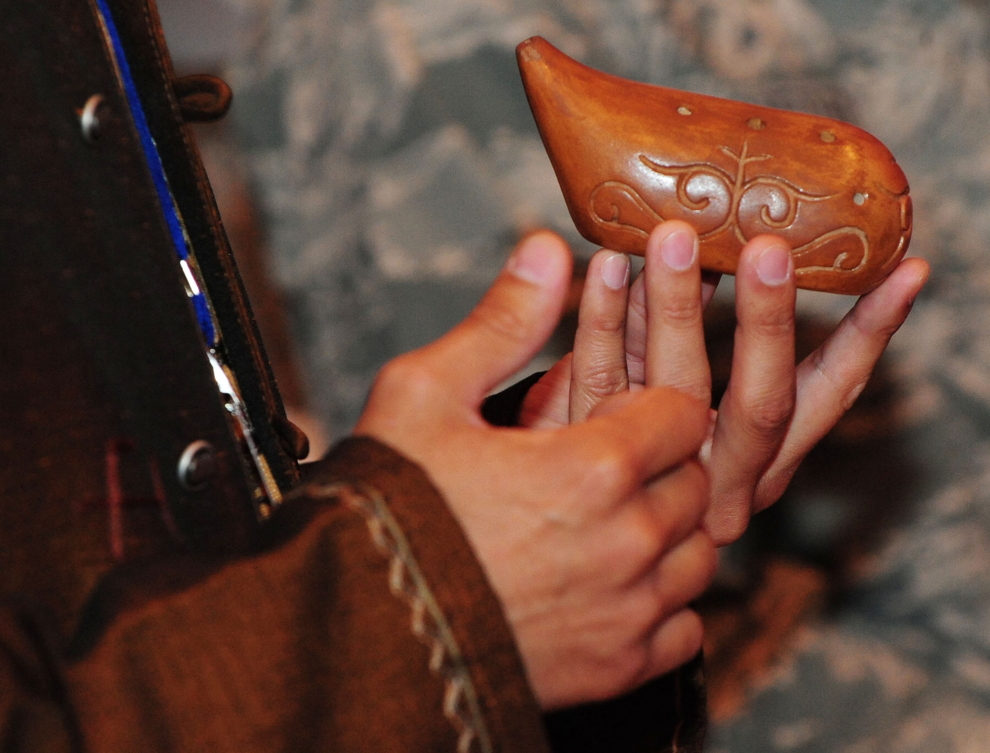 Asylbek Nasirdinov, a famous Kyrgyz musician, explains the traditional ancient Kyrgyz woodwind instrument during his performance for Airmen, community leaders, and students during the grand opening of the newly-constructed Yurt at the Transit Center at Manas, Kyrgyzstan, May 28, 2010. Airmen embraced the "spirit of Kyrgyzstan" by celebrating the most recent building here: a Yurt, which is the traditional nomadic Kyrgyz home and a structure which now symbolizes friendship between the United States and its host nation here. (U.S. Air Force photo/ Senior Airman Nichelle Anderson/ released)