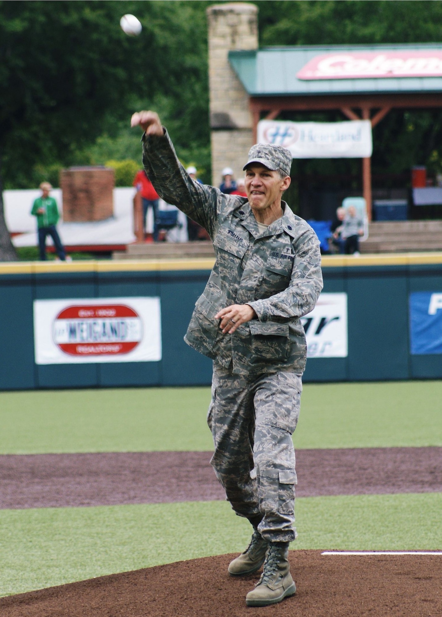The 184th Intelligence Wing was out in force at the WSU Baseball's Military
Appreciation Day ballgame on May 15th.  

After the posting of the colors 184th Head Chaplain and former WSU football
player, Lt Col Terry Williams, walked out to the pitcher's mound to throw
the ceremonial  "First Pitch".  While walking to the mound the announcer
shared Chaplain Williams' military and WSU biographies with the crowd.
Chaplain Williams graduated WSU in 1981 with a Bachelors Degree in Business.
He played football for the Shockers from 1977 to 1980 under Coach Willie
Jeffries as a free safety and was Co-Captain for the 1980 team. He was
awarded "Honorable Mention All-Missouri Valley" in 1980. The crowd showed
their respect by clapping and standing during the reading of his military
biography, but when they heard that Chaplain Williams was a former WSU
football player all 3,625 erupted in cheers. 

After the applause died down, the announcer told Chaplain Williams to, "show
us what you got". Good thing he was throwing to Shocker star outfielder Ryan
Jones because Chaplain Williams put a little too much zip on the throw and
Jones had to get out of his catcher's position to flag down the ball. Jones
got the ball and reigned in successfully.  It made for a good ending to great
start of WSU Baseball's Military Appreciation Day.
