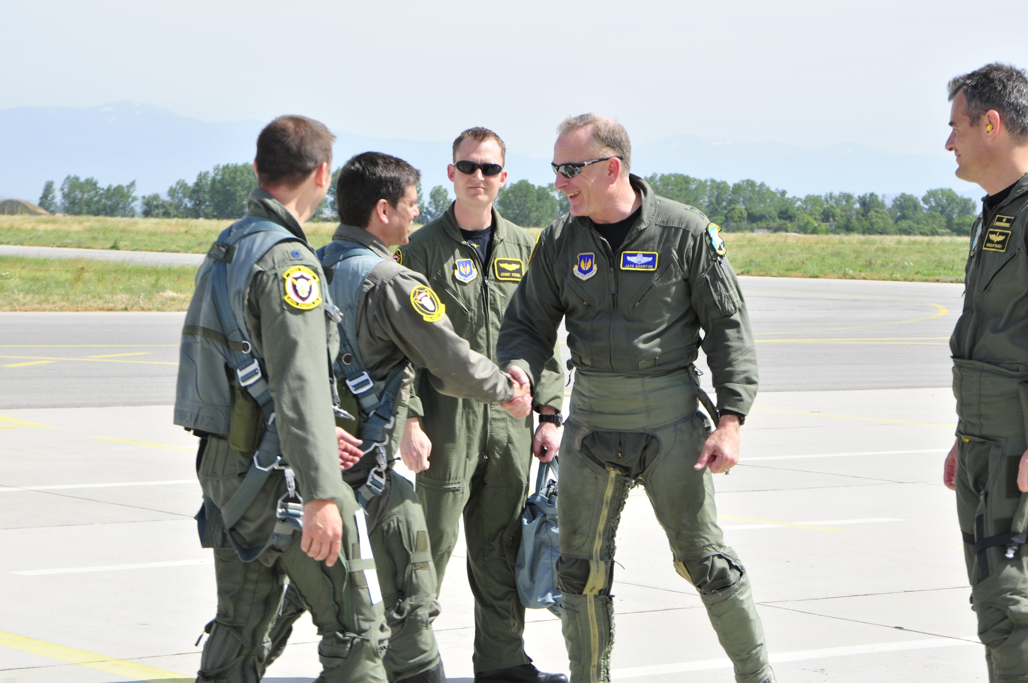 Maj. Gen. Jack Egginton (second from right), U.S. Air Forces in Europe director of air and space operations, shakes hands with Bulgarian air force Maj. Gen. Konstantin Popov, chief of air force training headquarters, while stepping to jets today. General Egginton flew in a MiG-29, and General Popov flew in an F-15. The generals were here to celebrate the end of a successful joint-exercise. Sentry Gold was held to build partnerships between the two air forces and continue Bulgaria’s integration into NATO. (U.S. Air Force photo/Airman 1st Class Tiffany M. Deuel)