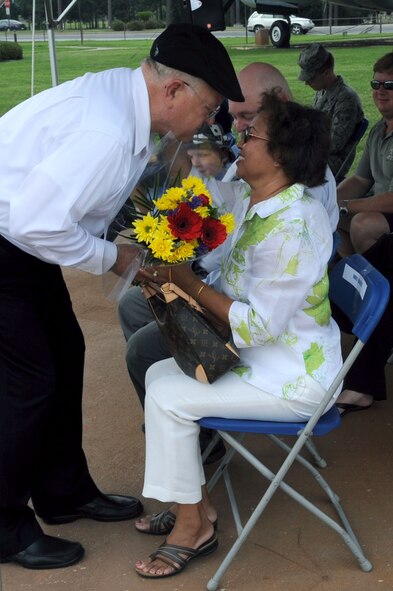 Bob Baker, 1st Special Operations Support Squadron’s airfield manager, hands his wife, Im, a bouquet of flowers during his retirement ceremony at the Airpark at Hurlburt Field, Fla., May 27, 2010. Mr. Baker completed his civil service career on the 55th anniversary of the day he enlisted in the Air Force. (DoD photo by U.S. Air Force Airman Caitlin O'Neil-McKeown)