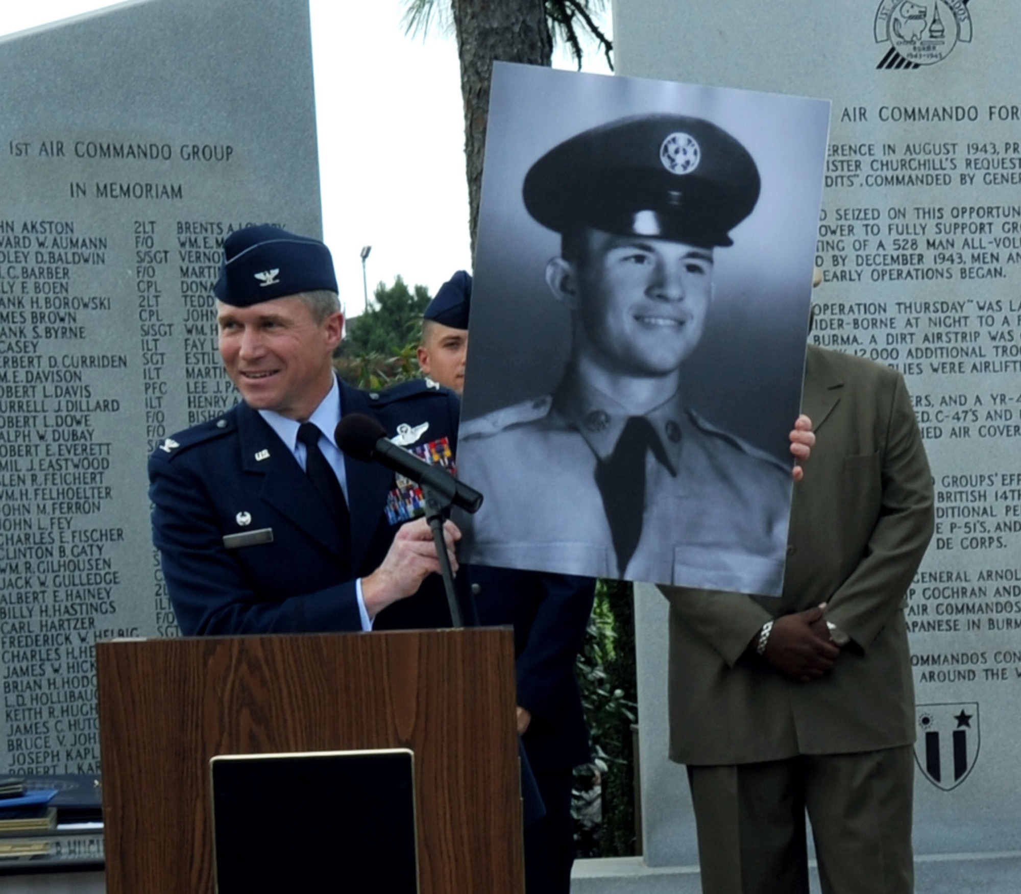 Col. Mark Alsid, U.S. Air Force Special Operations Training Center commander, holds up a picture of Bob Baker, 1st Special Operations Support Squadron’s airfield manager, when he was an Airman in the Air Force in 1955 during Mr. Baker's retirement ceremony at the Airpark at Hurlburt Field, Fla., May 27, 2010. Mr. Baker completed his civil service career on the 55th anniversary of the day he enlisted in the Air Force. (DoD photo by U.S. Air Force Airman Caitlin O'Neil-McKeown)
