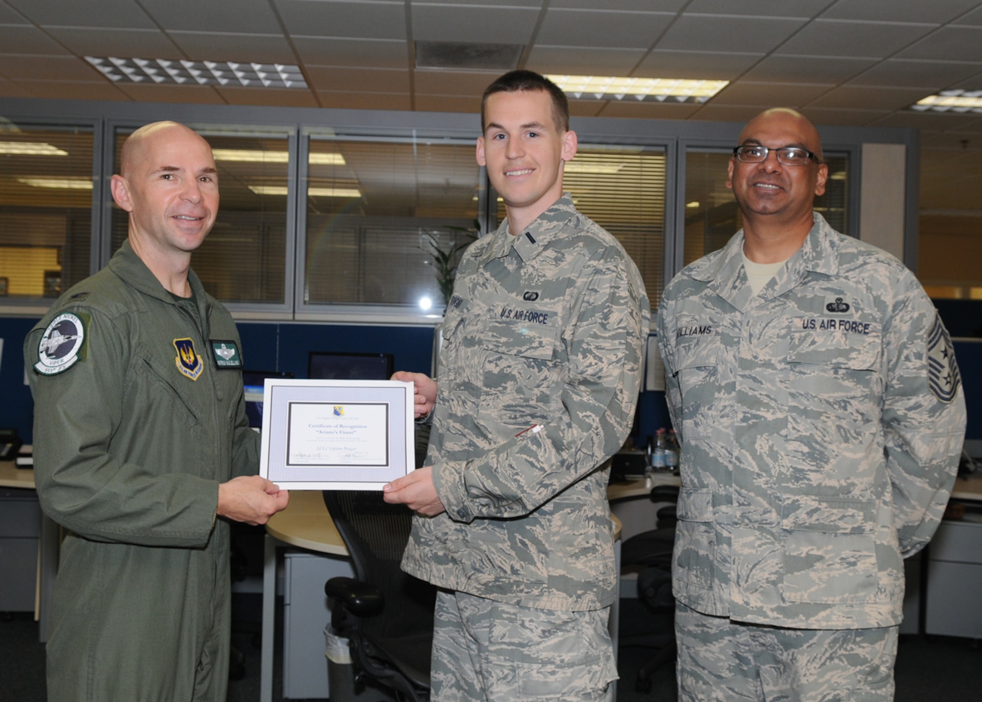 Col. Patrick A. McClelland, 31st Fighter Wing vice commander, congratulates 2nd Lt. Stephen Boogar, 31st Comptroller Squadron, Financial Services Flight , on his selection as one of Aviano's Finest as Chief Master Sgt. Laten Williams, 31st FW command chief, looks on. 
(U.S. Air Force photo/Staff Sgt. MercedesKimble Crossland)