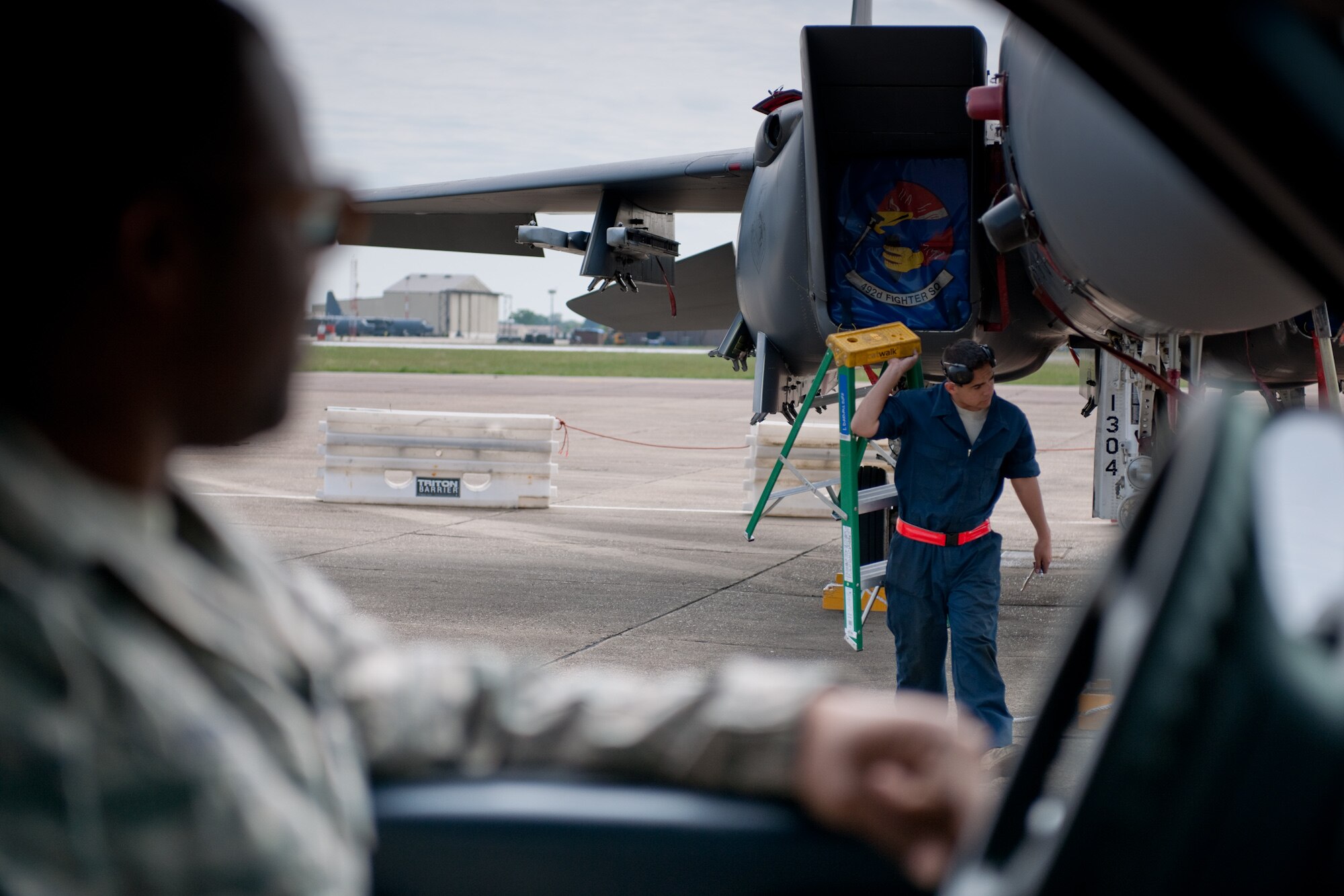 Staff Sgt. Timothy Miller, 48th Component Maintenance Squadron egress technician, watches from his truck as Airman 1st Class Raul Santos, 48th Aircraft Maintenance Squadron weapons team member, puts his ladder away after finishing a 30 and 60 day inspection on an F-15 at RAF Mildenhall, England, May 25. The maintenance squadrons are working out of RAF Mildenhall temporarily while their home runway at RAF Lakenheath, England, is being repaired.  (U.S. Air Force photo/Tech. Sgt. Nathan Gallahan)