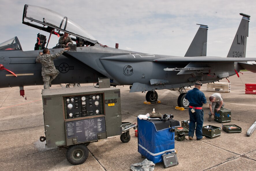 (Left) Staff Sgt. Timothy Miller and Tech. Sgt. Gilbert Wallers, both egress technicians with the 48th Component Maintenance Squadron egress technicians, remove pieces of equipment pilots use to breathe so they can be inspected. (Right) Airman 1st Class Raul Santos and Airman 1st Class David Hocker,  both 48th Aircraft Maintenance Squadron weapons team members, clean up their tools and equipment after finishing a 30 and 60 day inspection on an F-15 at RAF Mildenhall, England. The maintenance squadron is working out of RAF Mildenhall temporarily while their home runway at RAF Lakenheath, England, is being repaired.  (U.S. Air Force photo/Tech. Sgt. Nathan Gallahan)