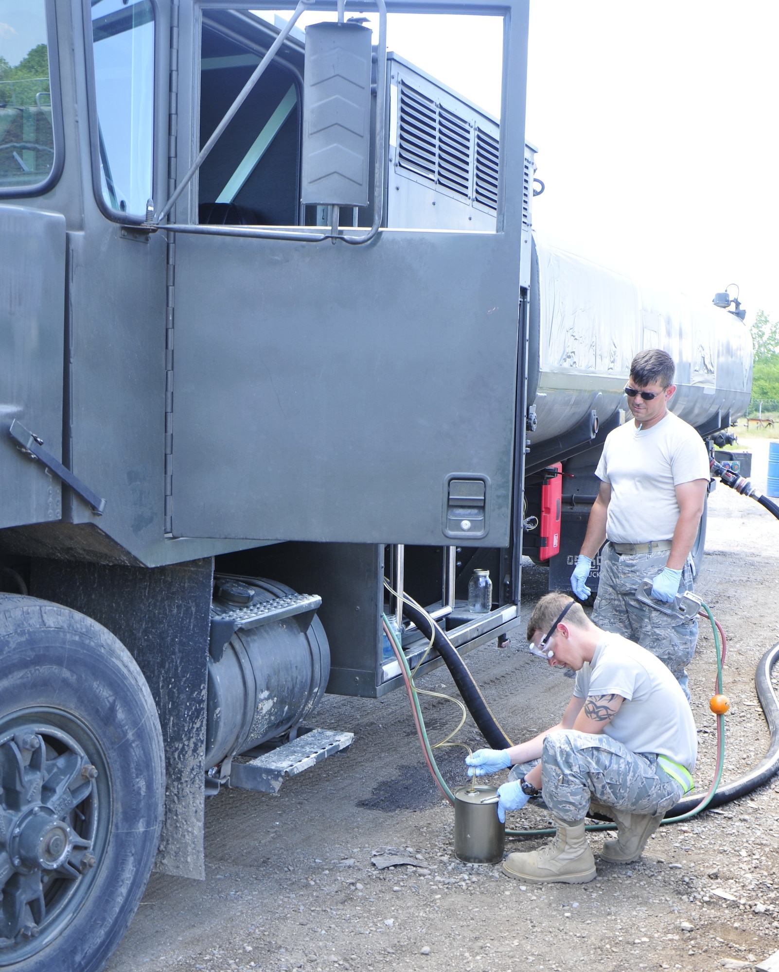 Senior Airman Wesley Anderson, 48th Logistics Readiness Squadron Petroleum, Oil and Lubricants lab technician, takes a fuel sample from the re-fueling truck as Tech. Sgt. Jackie Highlander, 48th Logistics Readiness Squadron Petroleum, Oil and Lubricants fuels, environmental and compliance inspector, oversees at Graf Ignatievo Air Force Base, Bulgaria, May 25. Samples are taken to ensure that the fuel has been successfully transformed from Jet A1 fuel to JP-8. Airman Anderson and Sergeant Highlander are part of the group of Airmen who are here to help integrate the Bulgarian air force into NATO and to build partnership capacities between the two air forces. (U.S. Air Force photo/Airman 1st Class Tiffany M. Deuel)