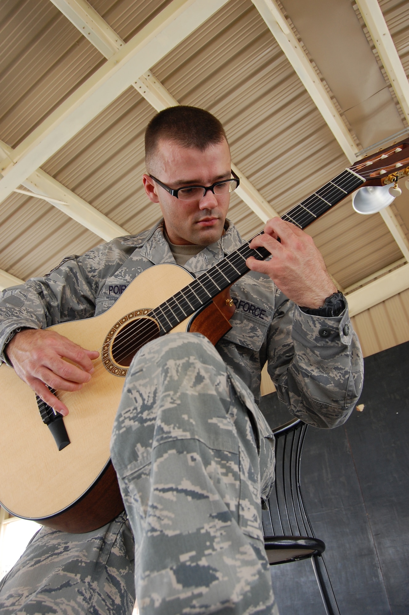 U.S. Air Force Staff Sgt. Israel Poire, 386th Expeditionary Civil Engineer Squadron structural journeyman, practices his guitar May 28, 2010 at an air base in Southwest Asia. The fingerstyle guitarist is a Mustang, Okla. native deployed from the 137th Civil Engineer Squadron at Will Rogers Air National Guard Base, Okla. (U.S. Air Force photo by Staff Sgt. Lakisha Croley/Released)