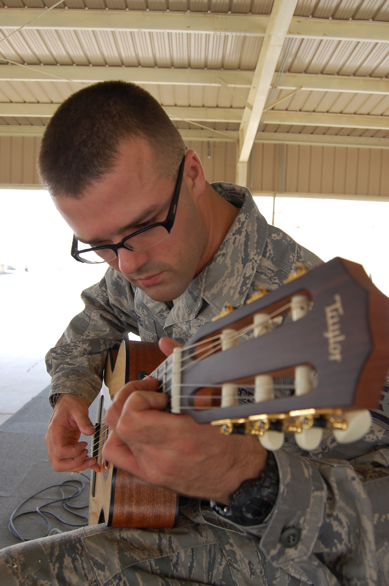 U.S. Air Force Staff Sgt. Israel Poire, 386th Expeditionary Civil Engineer Squadron structural journeyman, practices his guitar May 28, 2010 at an air base in Southwest Asia. The fingerstyle guitarist is a Mustang, Okla. native deployed from the 137th Civil Engineer Squadron at Will Rogers Air National Guard Base, Okla. (U.S. Air Force photo by Staff Sgt. Lakisha Croley/Released)