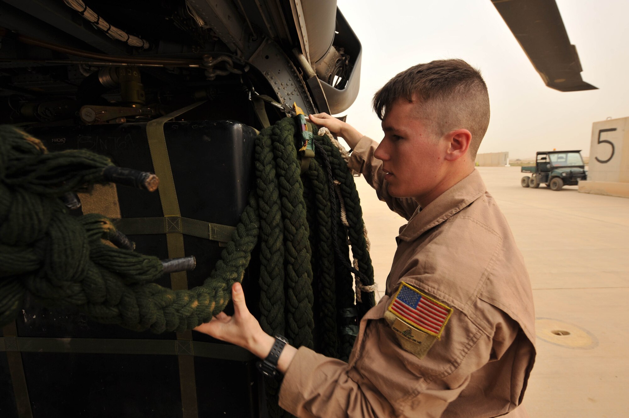 U.S. Air Force Senior Airman Joseph Arriza, an aerial gunner assigned to the 64th Expeditionary Rescue Squadron, hangs fast ropes in an HH-60 Pave Hawk helicopter for a training flight May 15, 2010, at Joint Base Balad, Iraq.  (U.S. Air Force photo/Staff Sgt. Quinton Russ/released)