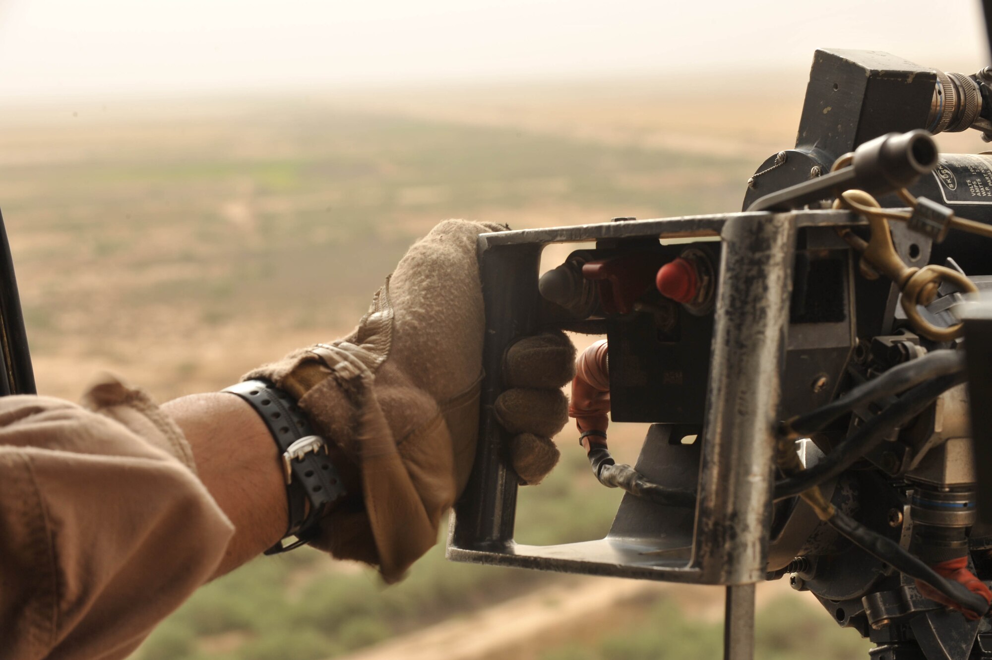 U.S. Air Force Staff Sgt. Dave Lamica, flight engineer assigned to the 64th Expeditionary Rescue Squadron, holds his GAU-2 mini-gun during a training flight at Joint Base Balad, Iraq, May 15, 2010.  Aircrews train to remain proficient and current on all aspects of the rescue mission. (U.S. Air Force photo/Staff Sgt. Quinton Russ/released)