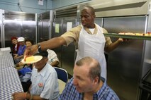 NEW YORK -- Capt. Afinju McDowell, movement control officer-in-charge of SPMAGTF NY, serves food at Williamsburg Senior Center. Several service members from the amphibious assault ship USS Iwo Jima, and Special Purpose Marine Air-Ground Task Force New York, visited with some of New York's senior citizens at the Jewish Association for Services for the Aged program's Williamsburg Senior Center in Brooklyn, N.Y., May 28, 2010, as part of Fleet Week New York's community outreach projects.ore than 3,000 Marines, Sailors and Coast Guardsmen are in the area participating in community outreach events and equipment demonstrations. This is the 26th year New York City has hosted the sea services for Fleet Week.