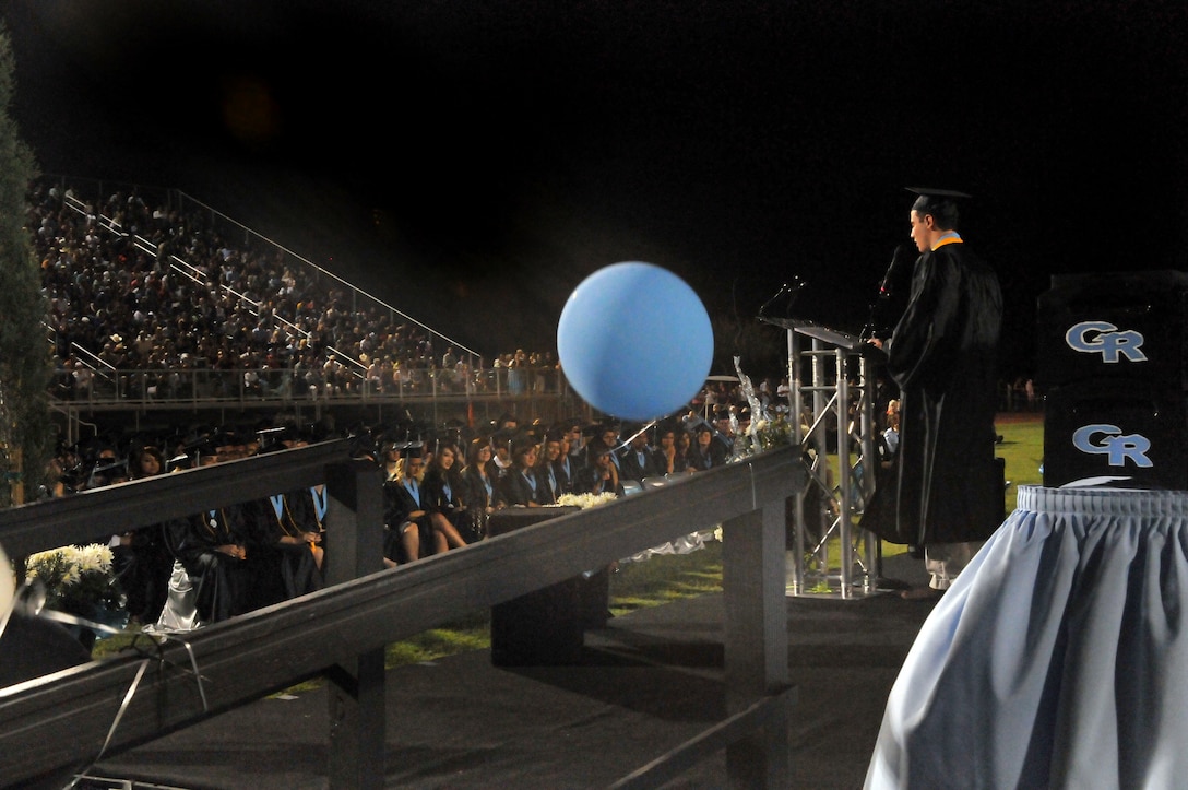Andrew Gough, son of Marine Attack Squadron 311 commanding officer Lt. Col. Michael Gough and Yuma, Ariz., Gila Ridge High School co-valedictorian, delivers a speech to his class during its graduation at Gila Ridge High School on April 28, 2010. The graduation, along with the graduations of Kofa High School and Yuma Catholic High School, was broadcast via the Web to VMA-311 Marines deployed with the 31st and 15th Marine Expeditionary Units. The broadcast was a combined effort between station personnel and local communications groups. “We’re treading new water,” said Elena McShane, station school liaison. “We know there are other schools in the country that are doing this, so why can’t Yuma?”