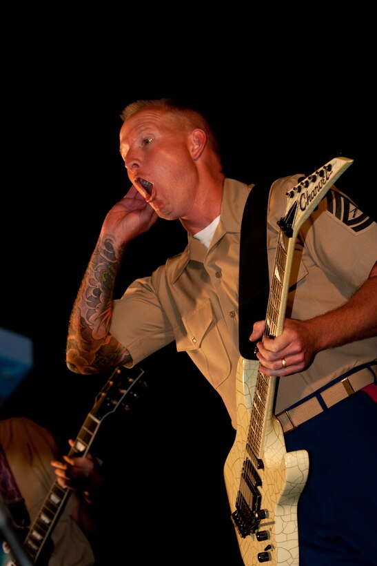 Gunnery Sgt. Clinton W. Walker, supply chief for Headquarters and Service Battalion, U.S. Marine Corps Forces, Pacific, and part time guitarist/ singer for the MarForPac Rock and Show Bands, asks the crowd if the music is loud enough during the Military Band Mele, May 29, at the Fort DeRussy Parade Grounds, here. ::r::::n::Walker has traveled and performed in several countries around the Pacific as a member of the MarForPac Band.