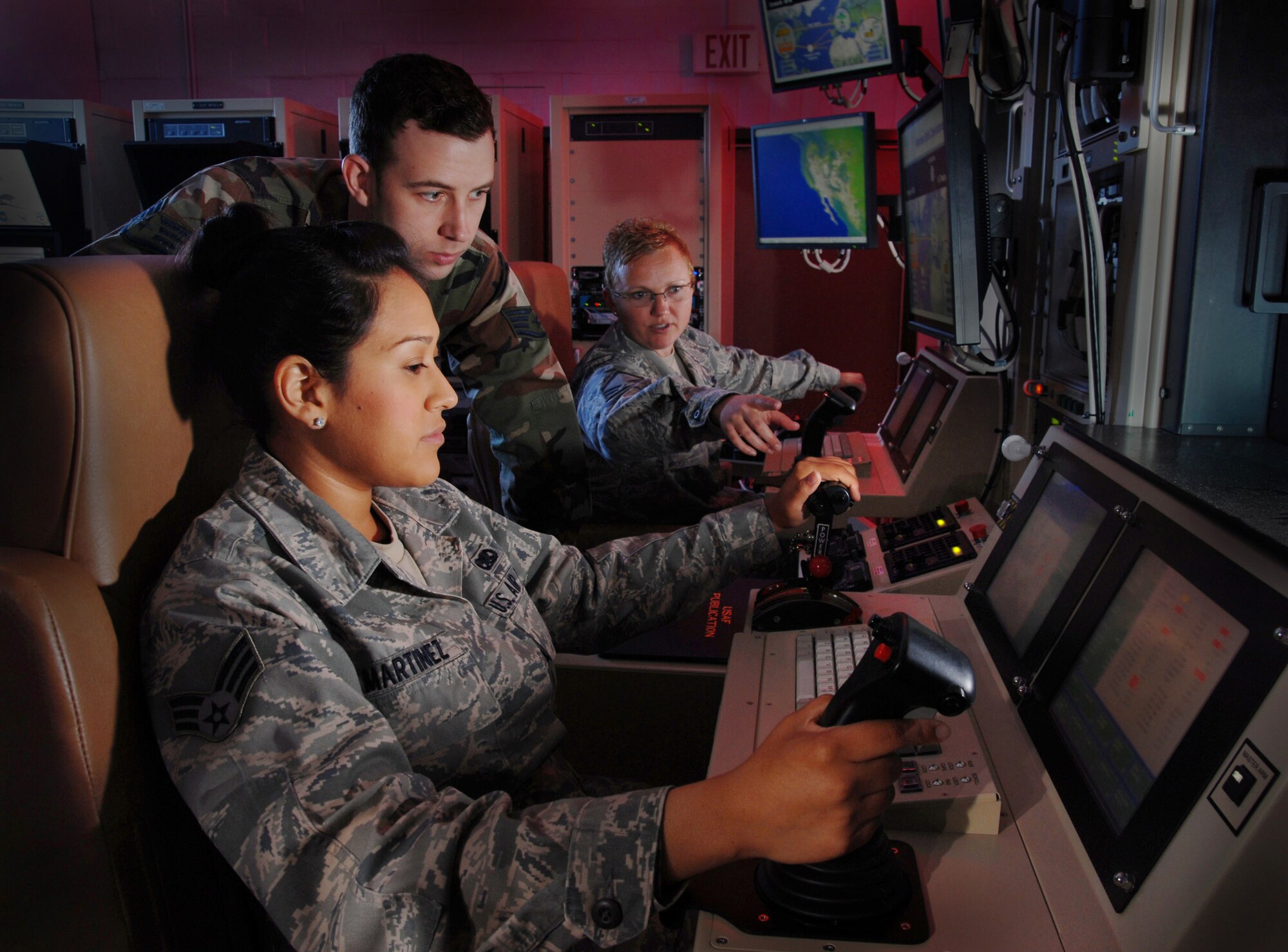 U.S. Air Force Master Sgt. Jennifer Oberg, background, a communications maintenance instructor, explains the features of a ground control station to Staff Sgt. Jason Avera, center, and Senior Airman Raquel Martinez, foreground, during training at March Air Reserve Base, Calif. All three are assigned to the 163rd Maintenance Group here. The unit, which is a part of the California Air National Guard, is primarily involved in the Predator missions. (U.S. Air Force photo by Val Gempis)