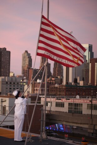 NEW YORK -- A sailor lowers the American Flag as part of the evening colors ceremony during the Sunset Parade on USS Iwo Jima, May 30, 2010, here. More than 3,000 Marines, Sailors and Coast Guardsmen are in the area participating in community outreach events and equipment demonstrations. This is the 26th year New York City has hosted the sea services for Fleet Week. (Official Marine Corps photo by Sgt. Randall A. Clinton / RELEASED)