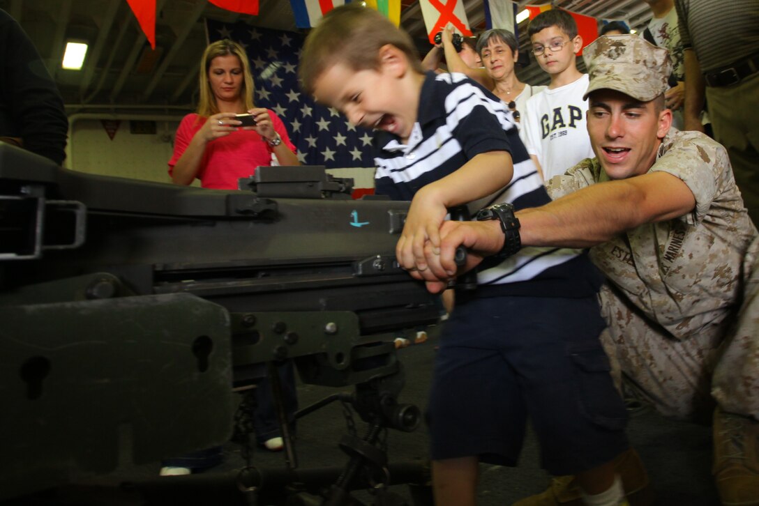 NEW YORK -- A Marine from 3rd Battalion, 9th Marine Regiment, Special Marine Air Ground Task Force New York, shows a child how to load the MK-19 automatic grenade launcher on USS Iwo Jima, here, May 29, 2010.   More than 3,000 Marines, Sailors and Coast Guardsmen are in the area participating in community outreach events and equipment demonstrations. This is the 26th year New York City has hosted the sea services for Fleet Week. (Official Marine Corps photo by Sgt. Randall A. Clinton / RELEASED)