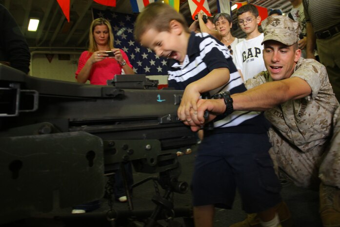 NEW YORK -- A Marine from 3rd Battalion, 9th Marine Regiment, Special Marine Air Ground Task Force New York, shows a child how to load the MK-19 automatic grenade launcher on USS Iwo Jima, here, May 29, 2010.   More than 3,000 Marines, Sailors and Coast Guardsmen are in the area participating in community outreach events and equipment demonstrations. This is the 26th year New York City has hosted the sea services for Fleet Week. (Official Marine Corps photo by Sgt. Randall A. Clinton / RELEASED)