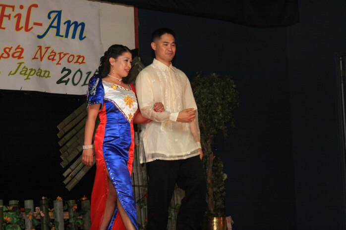 Laila Valiente is escorted by Ericson Encabo in the show during the Pistahan sa Nayon celebration at the Club Iwakuni Ballrom here May 29. The fashion show displayed traditional Filipino style clothing.
