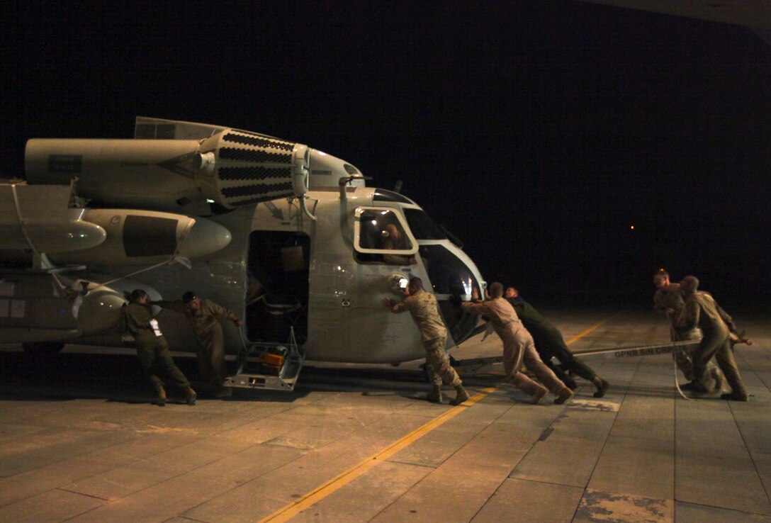 Marines push one of Marine Heavy Helicopter 363’s refurbished CH-53D helicopters on the flight line after rolling it out of an Air Force C-17 Globemaster III. The squadron is now preparing to redeploy to Marine Corps Base Hawaii Kaneohe Bay, Hawaii, after completing a seven month tour here. The Marines have flown more than 3,000 hours and transported more than 14,000 personnel during their deployment.