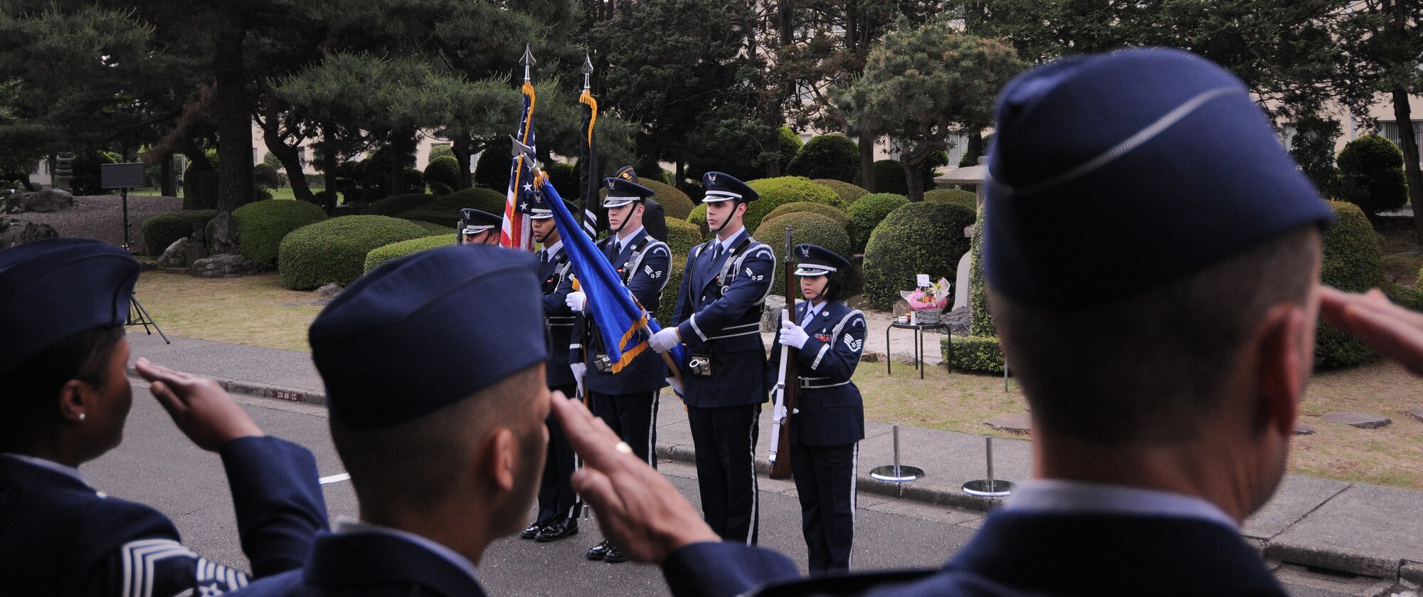 YOKOTA AIR BASE, Japan -- Airmen salute as members of the honor guard posts the colors during the Memorial Day ceremony at the Officer's Club here May 31. Memorial Day is observed on the last Monday of May and was designated to pay tribute to U.S. men and women who died while serving their country. Yokota's American Legion post 2222 holds the ceremony every year to carry on the tradition which first took place at Arlington National Cemetery in 1868. (U.S. Air Force photo/Airman 1st Class Lynsie Lorenz)