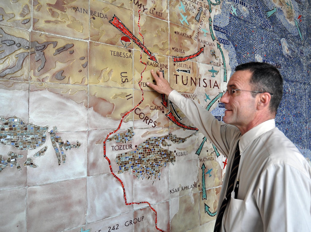 Carlos Castello, superintendant of the North Africa American Cemetery and Memorial in Carthage, Tunisia, points to the historic Battle of Kasserine Pass on a mosaic map depicting the World War II battles in North Africa, as cemetery staff prepared for the Memorial Day weekend May 28, 2010. U.S. Africa Command photo by Vince Crawley