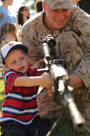 NEW YORK -- Marines from Special Purpose Marine Air Ground Task Force New York show visitors their weapons after a helicopter raid demonstration at Clove Lakes Park, Staten Island, New York, May 31.  More than 3,000 Marines, Sailors and Coast Guardsmen are in the area participating in community outreach events and equipment demonstrations. This is the 26th year New York City has hosted the sea services for Fleet Week.
