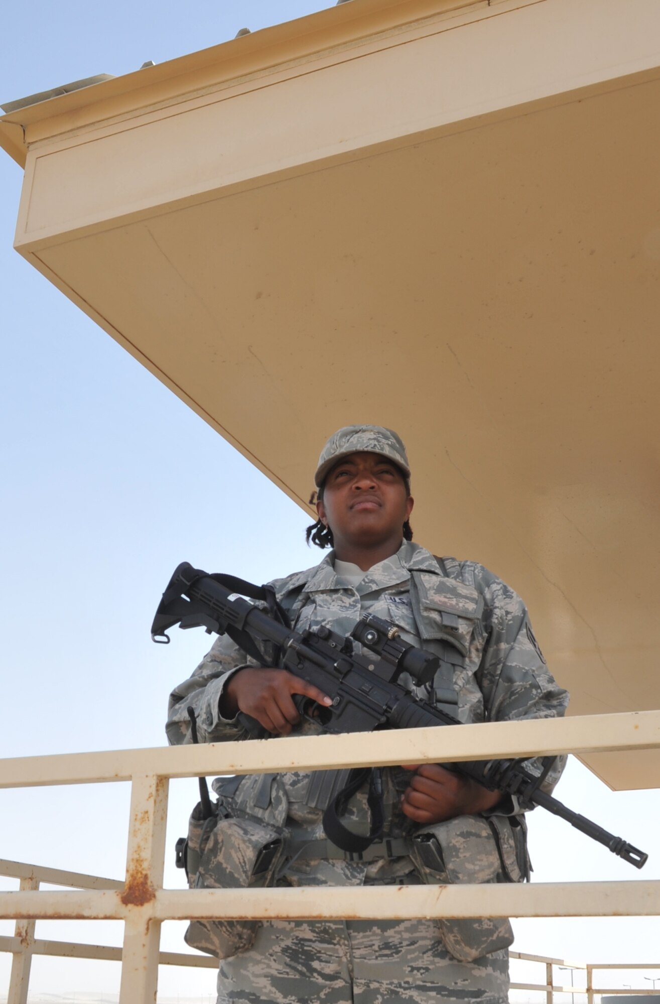 Airman 1st Class Cherece Gates, a security forces journeyman with the 380th Expeditionary Security Forces Squadron, watches over the perimeter fence from a security forces tower at a non-disclosed base in Southwest Asia. Airman Gates is deployed from the 27th Security Forces Squadron at Cannon Air Force Base, N.M., and her hometown is Elkhart, Ind. (U.S. Air Force Photo/Master Sgt. Scott T. Sturkol/Released)