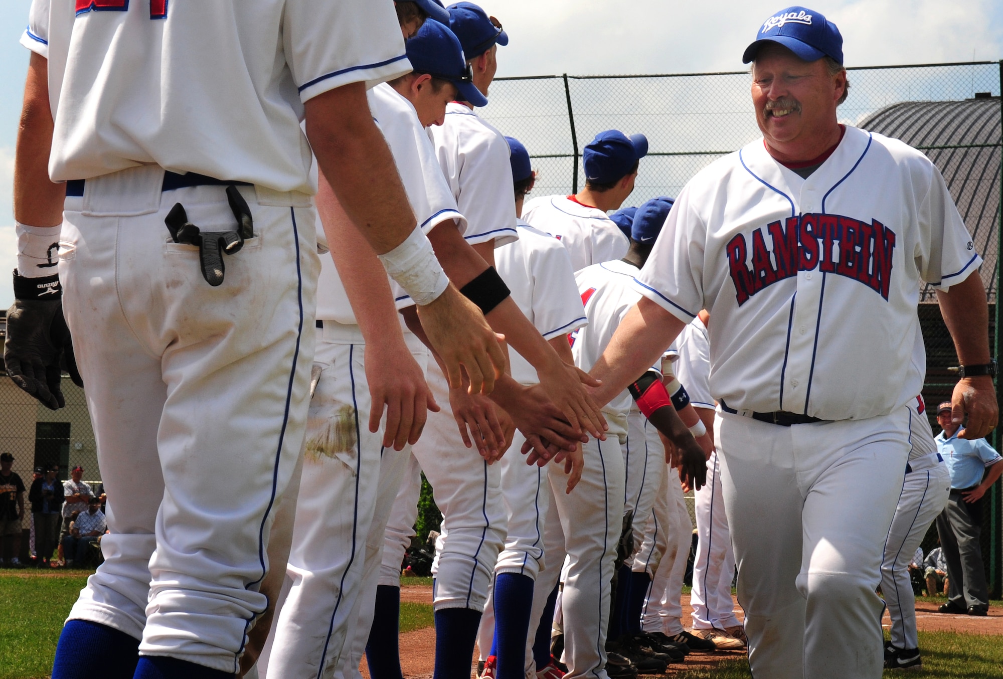 Head Coach of the Ramstein Royals High School baseball team Glenn Porter is greeted by members of his team during the their introduction before the final game against Patch Barracks at the Department of Defense Dependent Schools Europe Baseball European Championships, Ramstein Air Base, Germany, May 29, 2010. The three-day championships consisted of high school teams from all over the European theater in Divisions I, II and III.(U.S. Air Force photo by Staff Sgt. Jocelyn Rich))