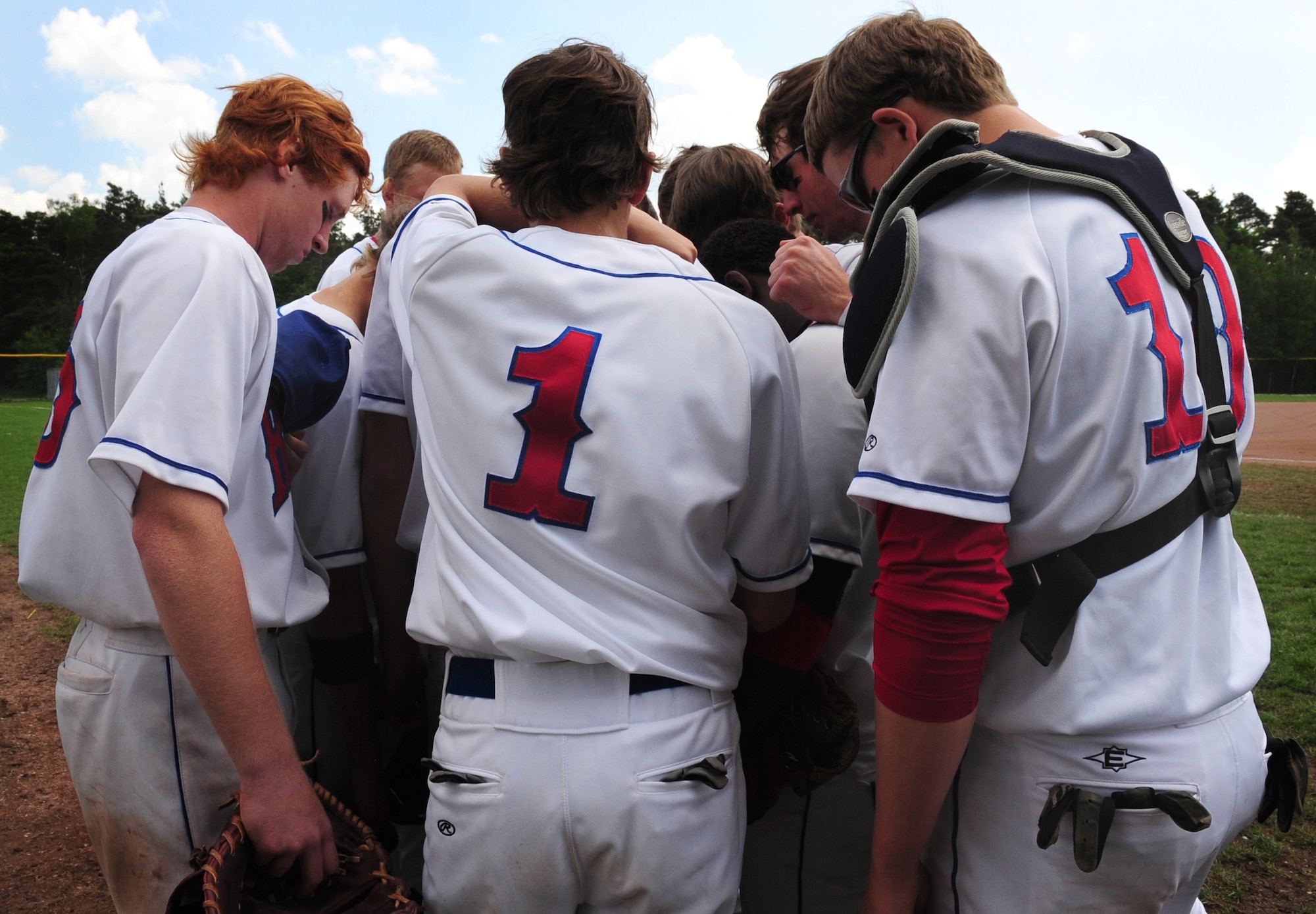 Members of the Ramstein Royals High School baseball team take a moment to bow their heads before their final game against the Patch Barracks High School baseball team during the last day of the Department of Defense Dependent Schools Europe Baseball European Championships, Ramstein Air Base, Germany, May 29, 2010. The three-day championships consisted of high school teams from all over the European theater in Divisions I, II and III. (U.S. Air Force photo by Staff Sgt. Jocelyn Rich)