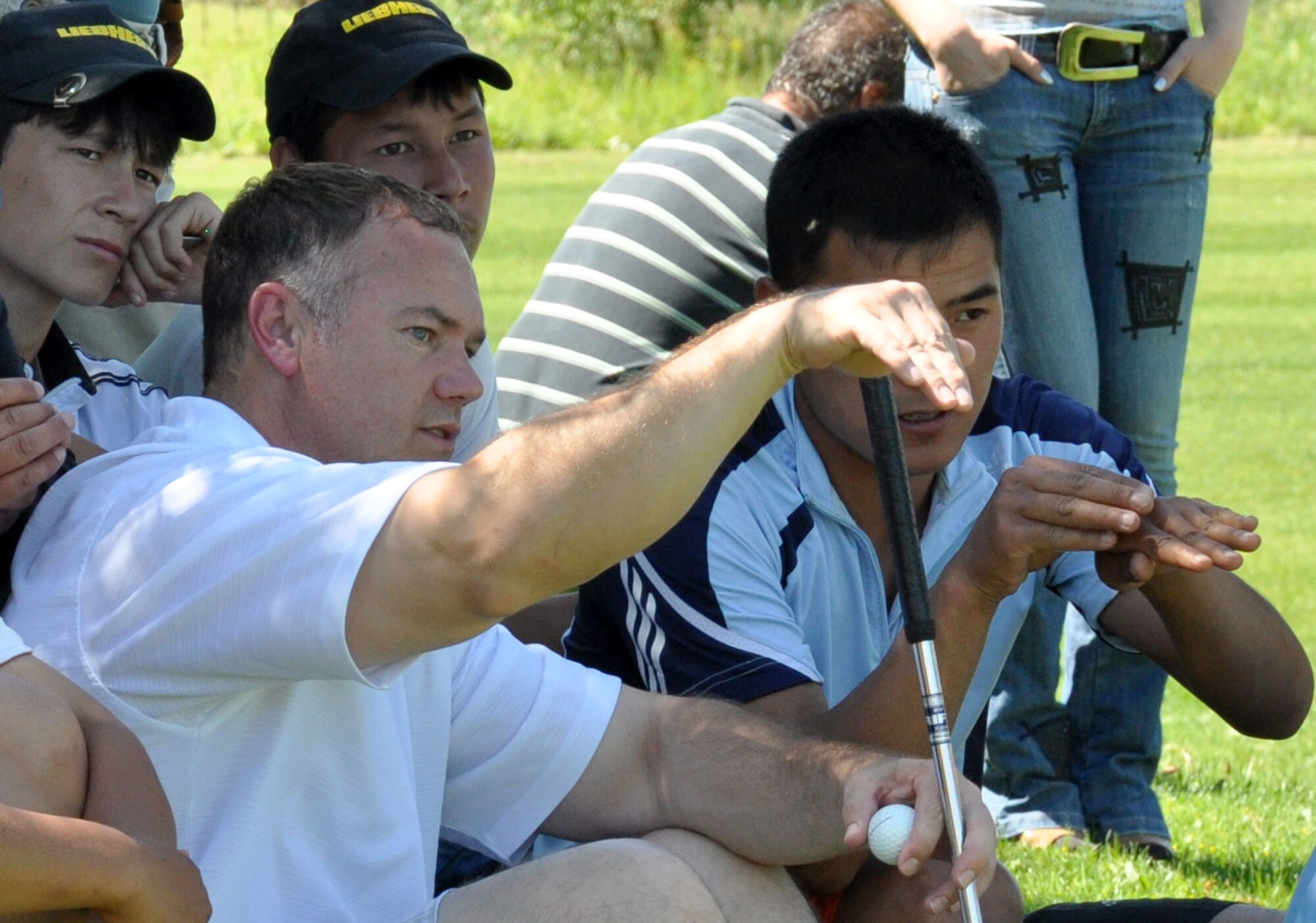 Don Smith, a 376th Expeditionary Civil Engineer Squadron?s fire and emergency services specialist, watches an opponent ?chip off? to determine the first place winner of a tie during the 3rd Annual Maple Leaf Golf Course ?Friends Support You? tournament May 29, 2010. His ?9-1-1? Team won first place for the second year in a row, out of about 85 participants. (U.S. Air Force photo/Staff Sgt. Carolyn Viss)
