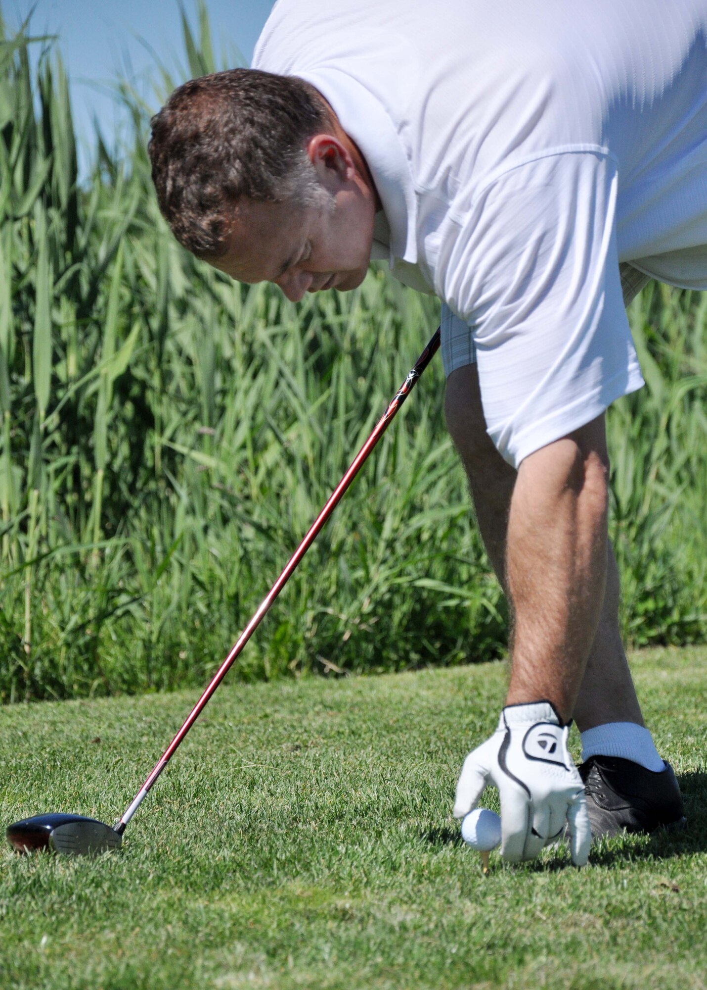 Don Smith, a 376th Expeditionary Civil Engineer Squadron?s fire and emergency services specialist, places his ball on a tee during the 3rd Annual Maple Leaf Golf Course ?Friends Support You? tournament May 29, 2010. For the second year in a row, his team won first place in the event, which benefitted Ed Miles, the owner of the course, who was diagnosed with bladder cancer this year. (U.S. Air Force photo/Staff Sgt. Carolyn Viss)