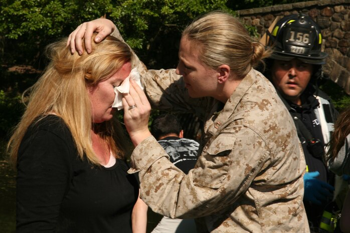 NEW YORK -- Capt. Lauren Schulz, deputy director, Headquarters Marine Corps, Division of Public Affairs, New York City, administers first aid to a guest at a helicopter raid demonstration at Clove Lakes Park, Staten Island, New York, May 31. The MV-22 Osprey's rotor wash caused branches to fall as it landed at the park. Marines from the raid force immediately rushed to assist those affected by the falling debris. Ten spectators were treated at a local hospital and released within hours. (Official Marine Corps photo by Cpl. James Cline / RELEASED)