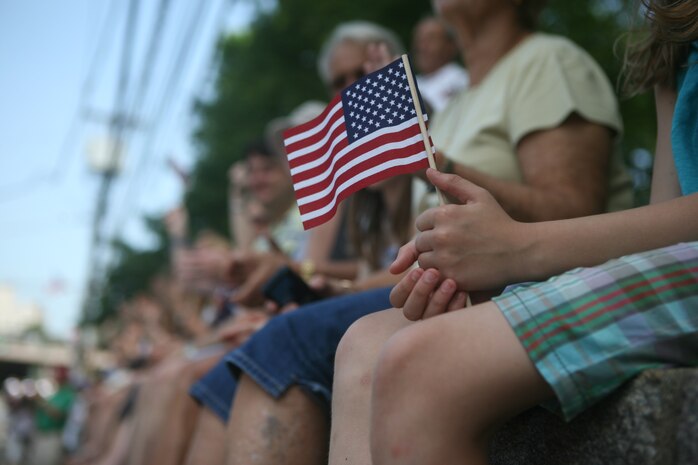 PELHAM, N. Y. - A Pelham girl holds a flag as Special Purpose Marine Air Ground Task Force New York Marines march by as part of the town's Memorial Day ceremonies May 31. The Marines were on hand as part of Fleet Week New York 2010. More than 3,000 Marines, Sailors and Coast Guardsmen are in the area participating in community outreach events and equipment demonstrations. This is the 26th year New York City has hosted the sea services for Fleet Week.