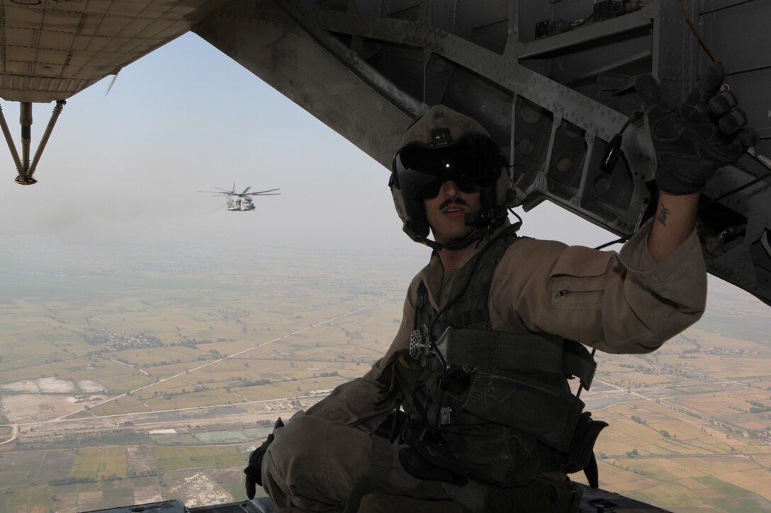 Sergeant Leo Parry II, a CH-53E Super Stallion Helicopter crew chief with Marine Medium Tiltrotor Squadron 266 (Reinforced), 26th Marine Expeditionary Unit, reaches for a bottle of water after delivering World Food Progamme relief supplies to Hassan Khan Jamali, Pakistan, Nov. 1, 2010. With the Pakistan military, 26th Marine Expeditionary Unit Marines have been flying CH-53E Super Stallion Helicopters to isolated locations in Sindh province since early September and have transported more than 3.7 million pounds of relief supplies to 150 different locations in southern Pakistan. (Official USMC photo by Gunnery Sgt. Bryce Piper) (Released)