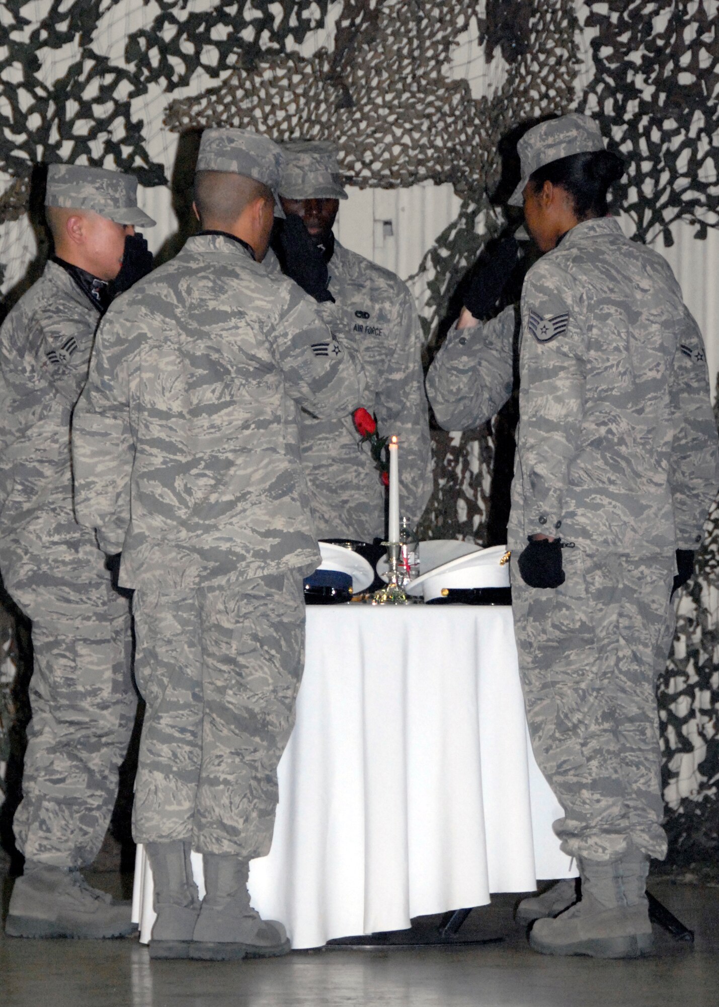 Airmen from the 8th Fighter Wing base honor guard show their respect to the POW/MIA table by saluting to their missing comrades who could not attend the Combat Dining-In here in Hangar 3 Oct. 30.  The POW/MIA table was one the traditions practiced at the military event that gathered more than 400 attendees.   (U.S. Air Force photo/Capt. Sheryll Klinkel)