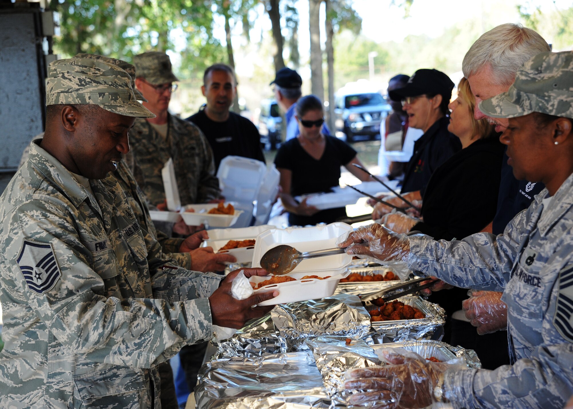 Chief Master Sgt. Gigi Manning serves up fish and sides to hungry customers at the Chiefs Fish Fry Oct. 29, 2010, on Joint Base Charleston, S.C. Chiefs served fried fish fillets, jalapeno poppers, coleslaw, beans and more during the barbeque event. Chief Manning is the new command chief for the 315th Airlift Wing. (U.S. Air Force photo/Senior Airman Timothy Taylor)