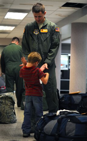 Capt. Matt Carducci and his son Luke high-five at the passenger terminal on Joint Base Charleston, S.C., as Captain Carducci prepares to deploy with the 16th Airlift Squadron to the Middle East Oct. 28, 2010, where they will be deployed for four months. The squadron will be deployed for four months. Captain Carducci is a C-17 pilot with the 16 AS. (U.S. Air Force Photo/Airman 1st Class Lauren Main)