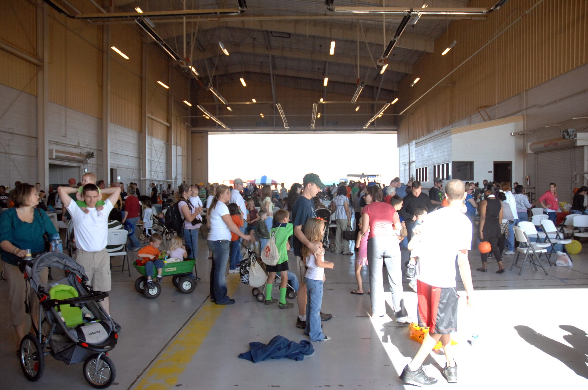 Airmen and their families enjoy the fall festival held in Hangar 208 here October 30. The event featured aircraft displays, food, games, information booths and more. (U.S. Air Force photo by Senior Airman Elliott Sprehe)