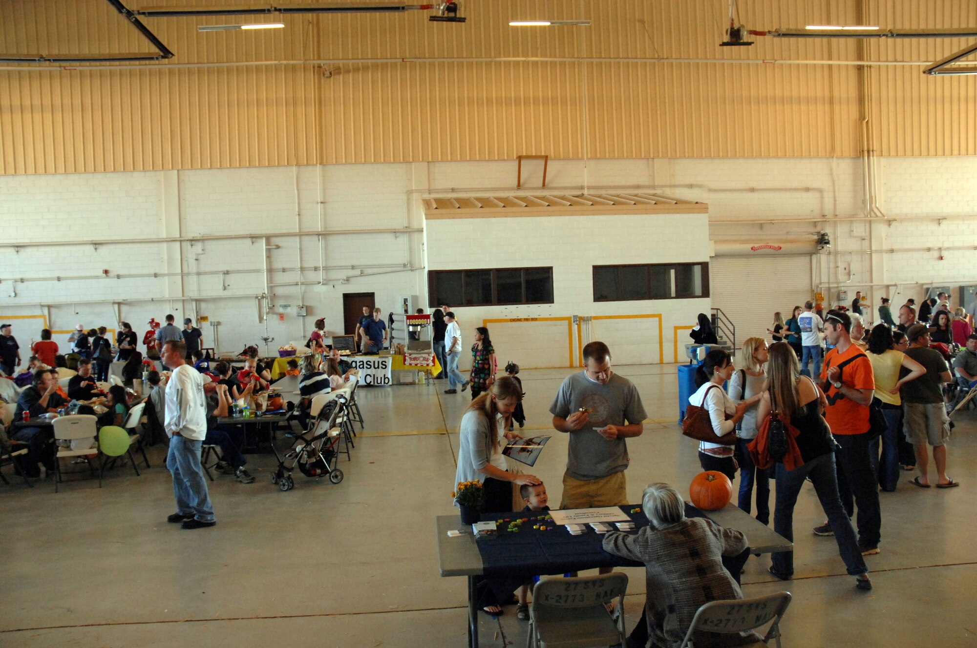 Airmen and their families enjoy the fall festival held in Hangar 208 here October 30. The event featured aircraft displays, food, games, information booths and more. (U.S. Air Force photo by Senior Airman Elliott Sprehe)