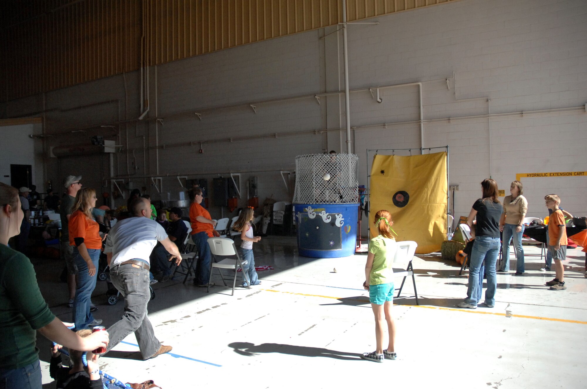 Airmen and their families enjoy the dunk tank during the fall festival held in Hangar 208 here October 30. The event featured aircraft displays, food, games, information booths and more. (U.S. Air Force photo by Senior Airman Elliott Sprehe)