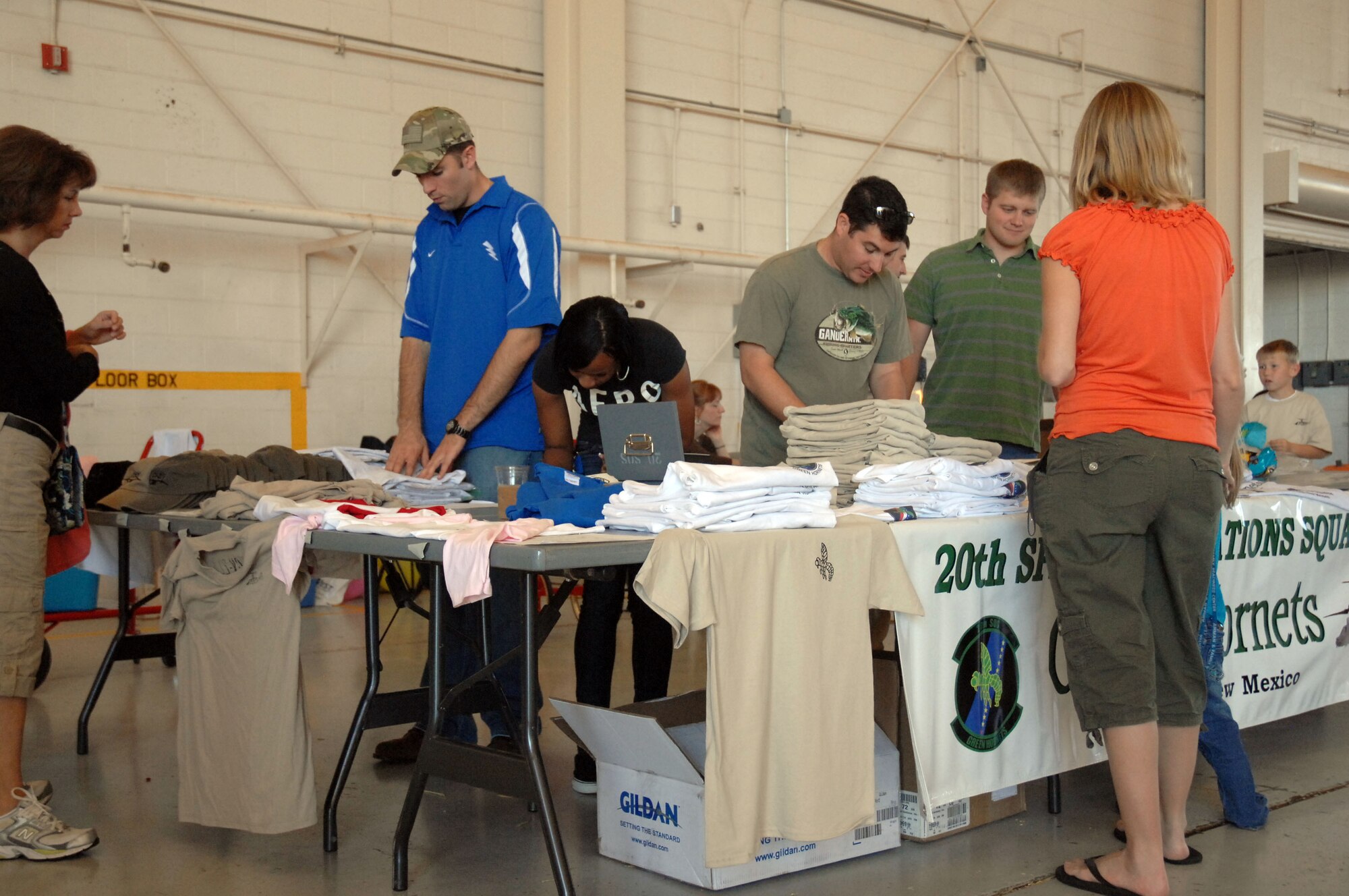 Airmen with the 20th Special Operations Squadron man their merchandise table during the fall festival held in Hangar 208 here October 30. The event featured aircraft displays, food, games, information booths and more. (U.S. Air Force photo by Senior Airman Elliott Sprehe)