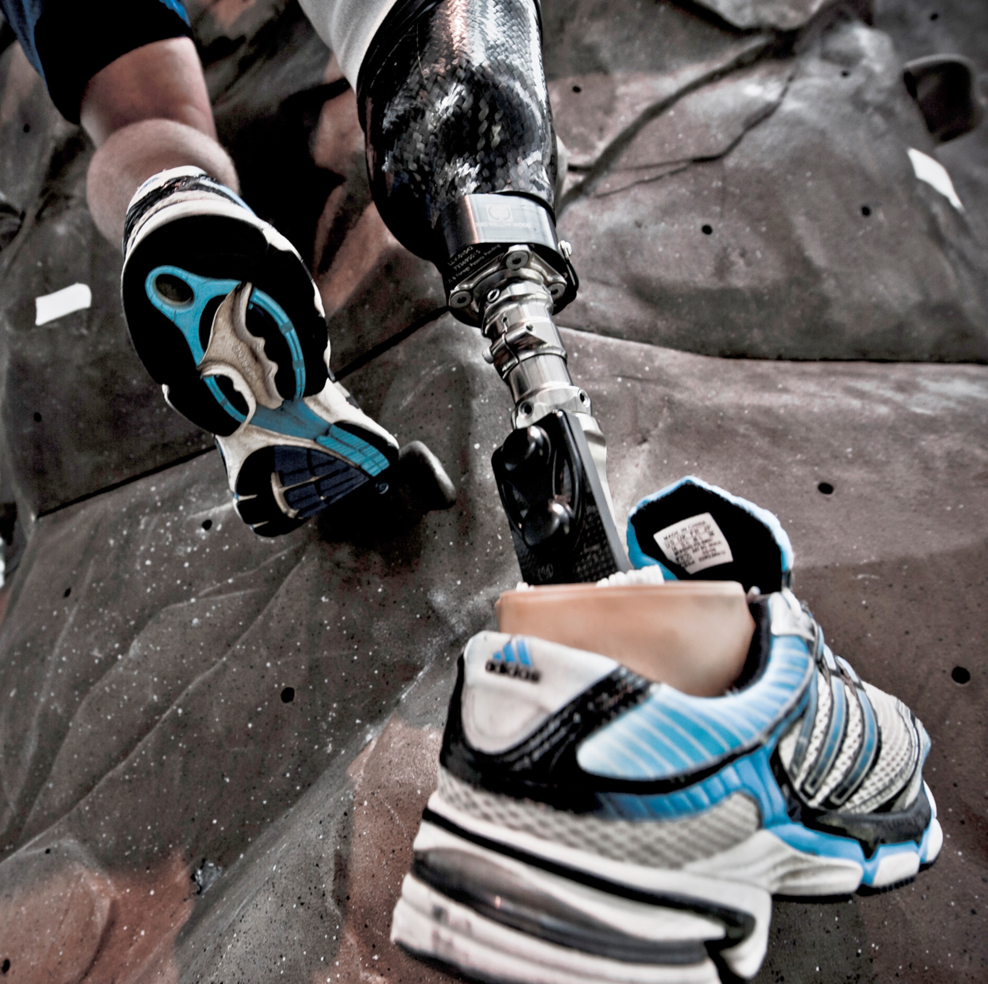 1st Lt. Ryan McGuire conquers the rock climbing wall at the Center for the Intrepid as part of his physical therapy session with therapist Alicia White (holding the safety rope) May 25, 2010, in San Antonio. The rehabilitation therapy helped the lieutenant get used to the prosthetic he received after his lower right leg was amputated following a boating mishap in Sept. 2009. (U.S. Air Force photo/Tech. Sgt. Samuel Bendet)