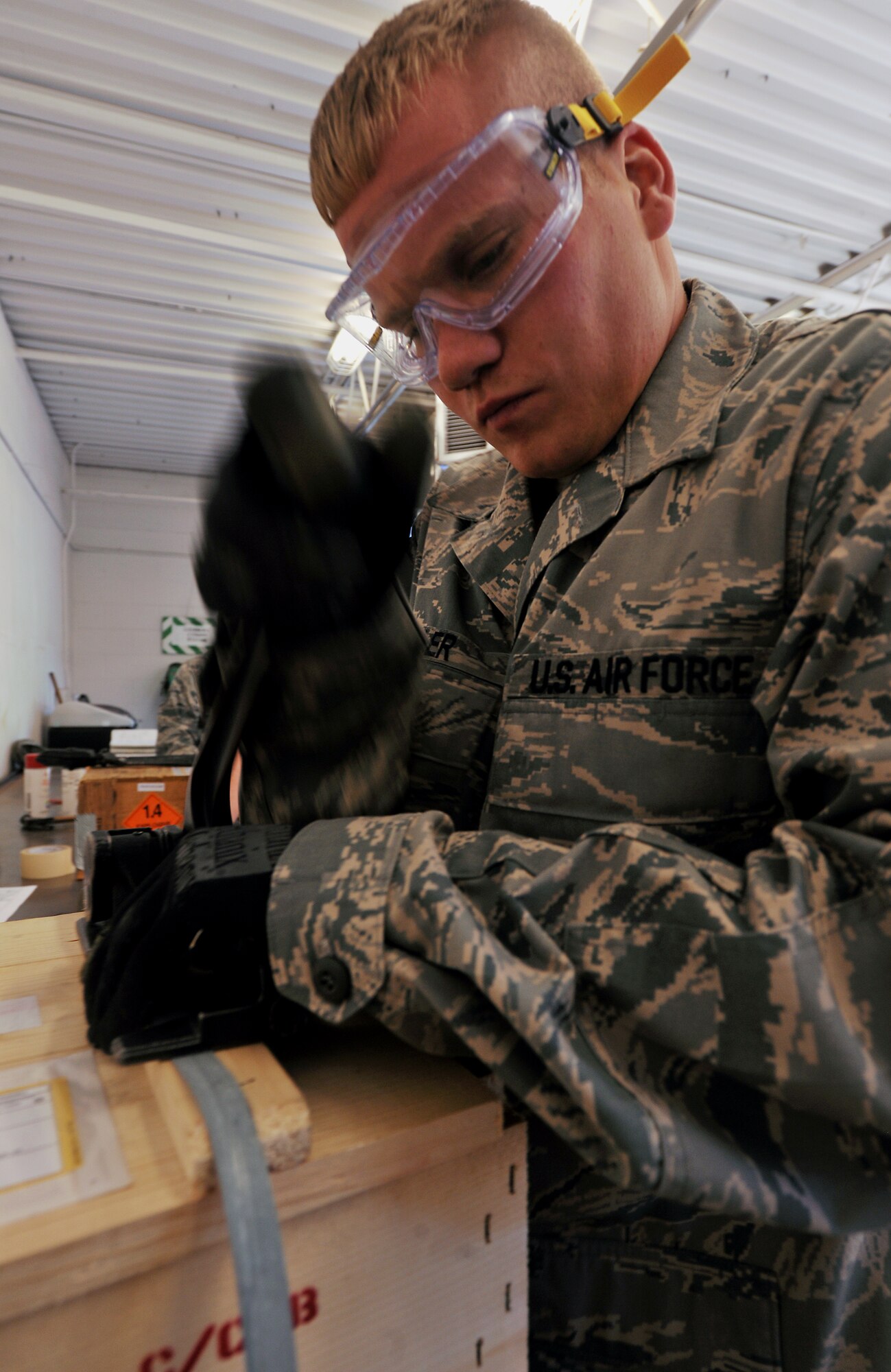 MOODY AIR FORCE BASE, Ga. -- Senior Airman Kyle Detwiller, 23rd Equipment Maintenance Squadron munitions flight stock pile surveillance crew chief, tightens straps on a munitions package during munitions inspector training course here Nov 1. After every munitions box is inspected and labeled correctly, the munitions package must be strapped down and sealed to ensure proper storage and protection. (U.S. Air Force photo/Airman 1st Class Joshua Green)(RELEASED)

