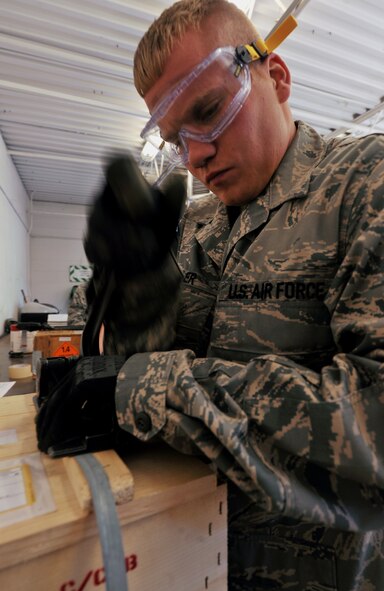 MOODY AIR FORCE BASE, Ga. -- Senior Airman Kyle Detwiller, 23rd Equipment Maintenance Squadron munitions flight stock pile surveillance crew chief, tightens straps on a munitions package during a munitions inspector training course here Nov 1. After every munitions box is inspected and labeled correctly, the munitions package must be strapped down and sealed to ensure proper storage and protection. (U.S. Air Force photo/Airman 1st Class Joshua Green)(RELEASED) 

