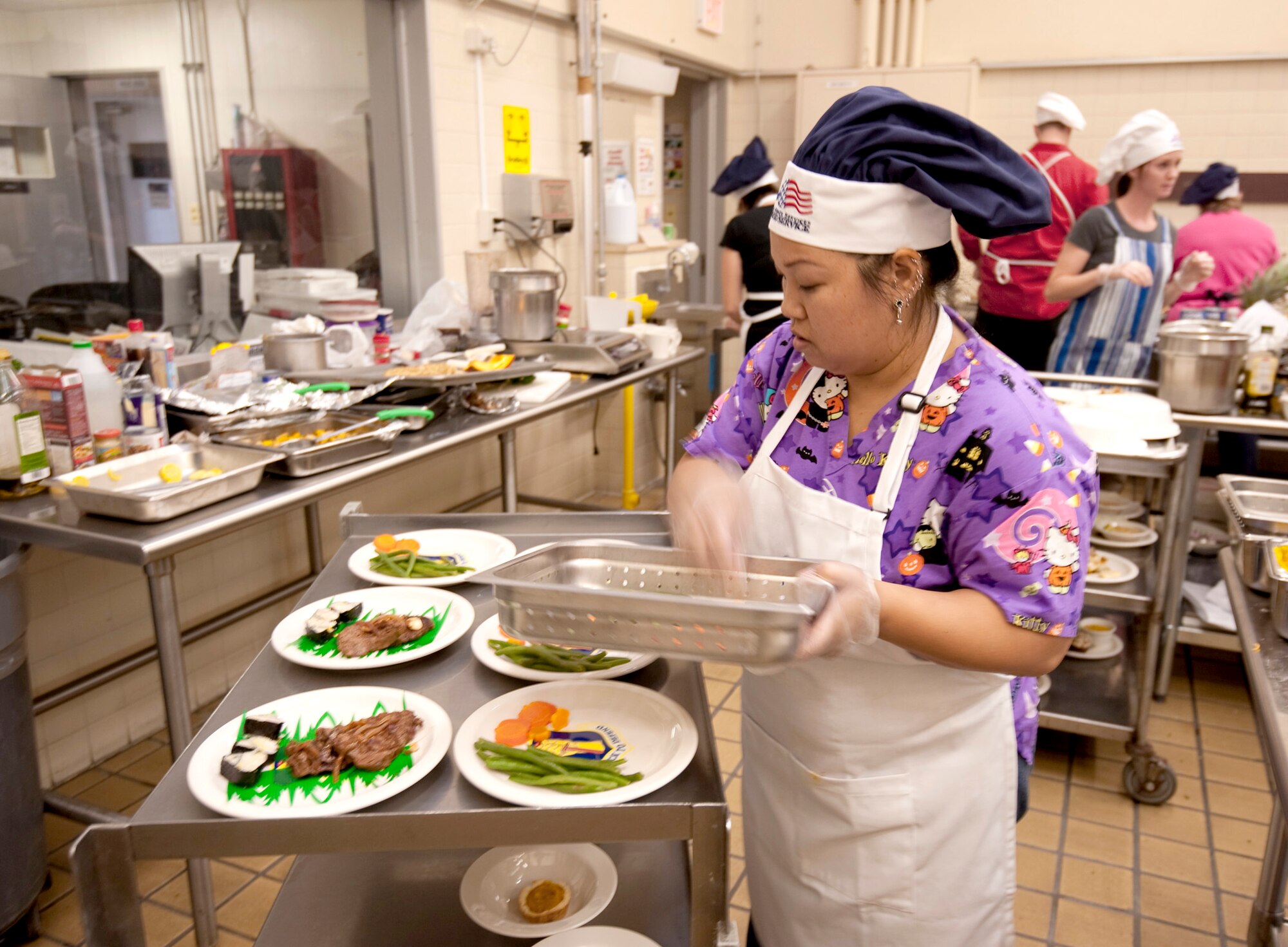 Jennifer Tengco, a Navy spouse, garnishes her edible creations for the "Fit to Fight" Iron Chef competition Oct. 27, 2010, at Misawa Air Base, Japan. The iron chef contestants had one hour and 30 minutes to prepare and cook their cuisine, and an additional 15 minutes to garnish and plate their dishes. (U.S. Air Force photo/Airman James B. Bauer)
