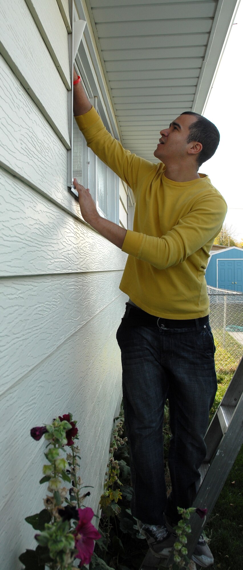 Staff Sgt. Ernesto Roman-Cruz, 341st Operations Support Squadron missile chef trainer, cleans windows during the Day of Caring Oct. 22 in Great Falls, Mont. More than 170 Malmstrom Total Force Airmen and Federal employees volunteered their time to help elderly and disabled members of the local community with household chores. (U.S. Air Force photo/Staff Sgt. Dillon White)