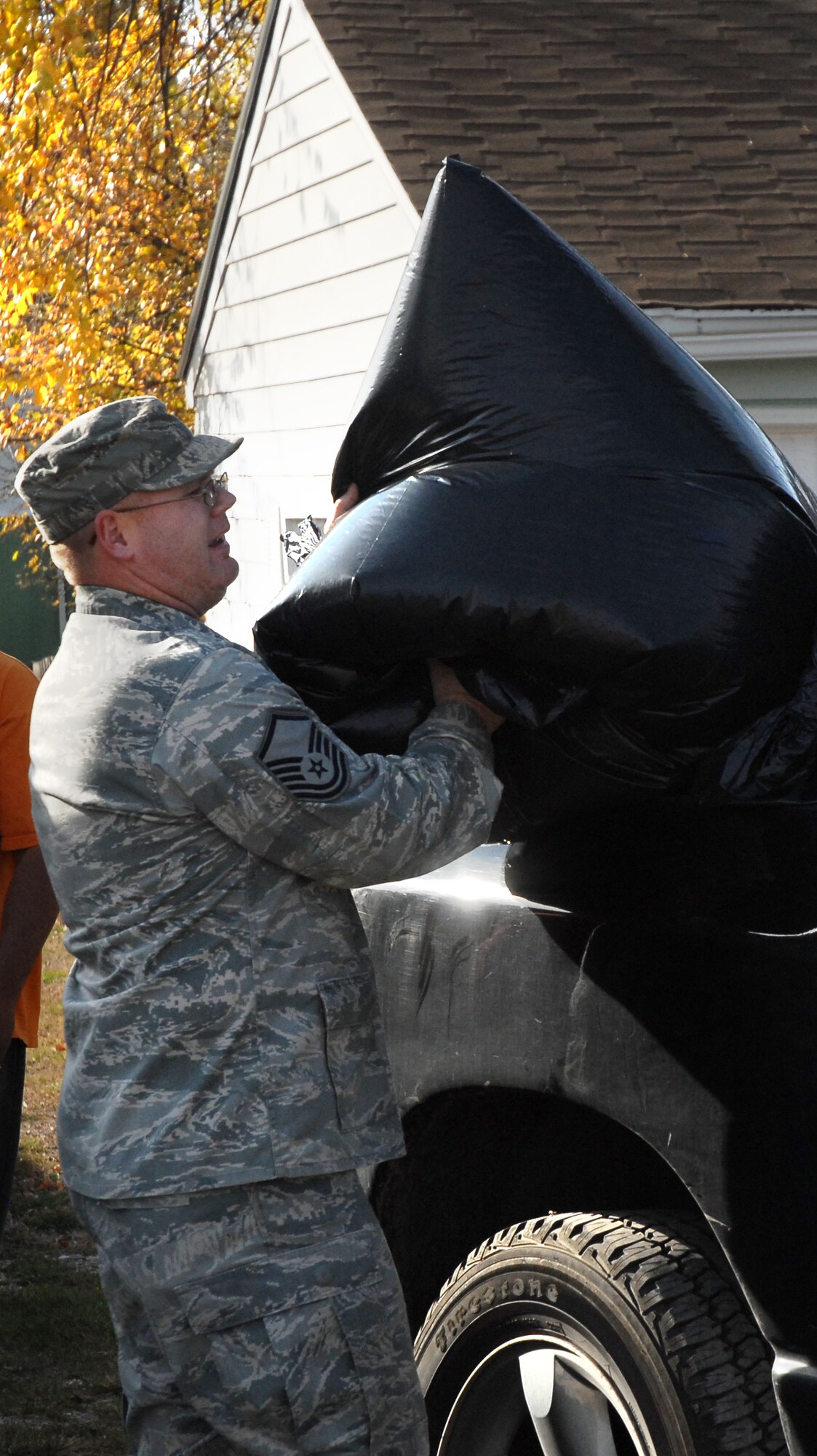 Master Sgt. Daniel Miller, 12th Missile Squadron superintendent, heaves a bag of raked leaves into a truck in Great Falls, Mont., Oct. 22 during the Day of Caring. The Day of Caring is held in conjunction with the Combined Federal Campaign and is held to give elderly people in the local community a hand with chores they're no longer physically able to do themselves. (U.S. Air Force photo/Staff Sgt. Dillon White)