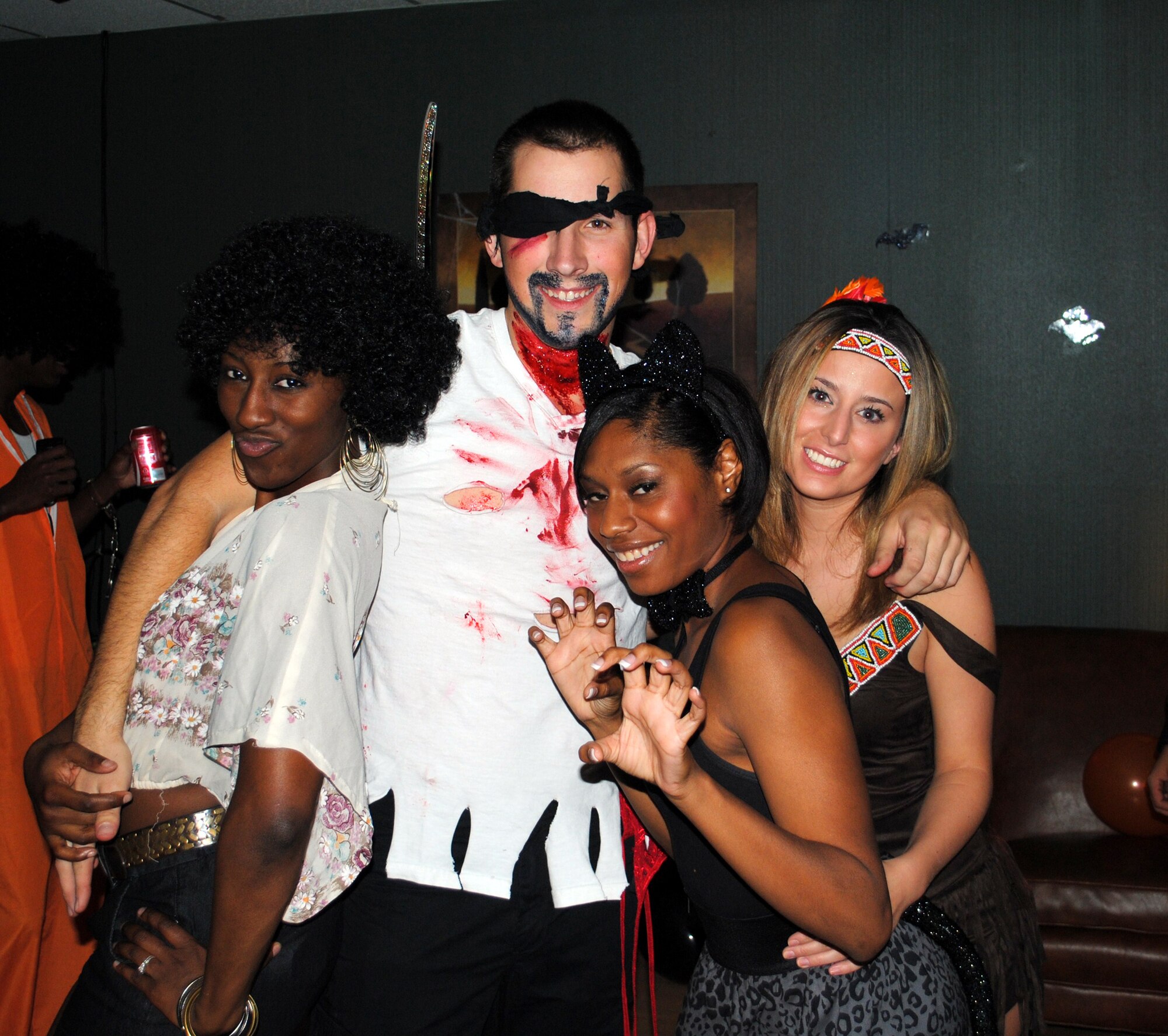 From left, Airmen 1st Class Kristina Overton and Zachary Freeman, and Senior Airmen Dynesha Adams and Patricia Carnahan, Airman’s Council executive members, huddle up for a group shot at the Airman’s Council Halloween party Oct. 22 at the Detour.(U.S. Air Force photo/Airman 1st Class Kristina Overton)