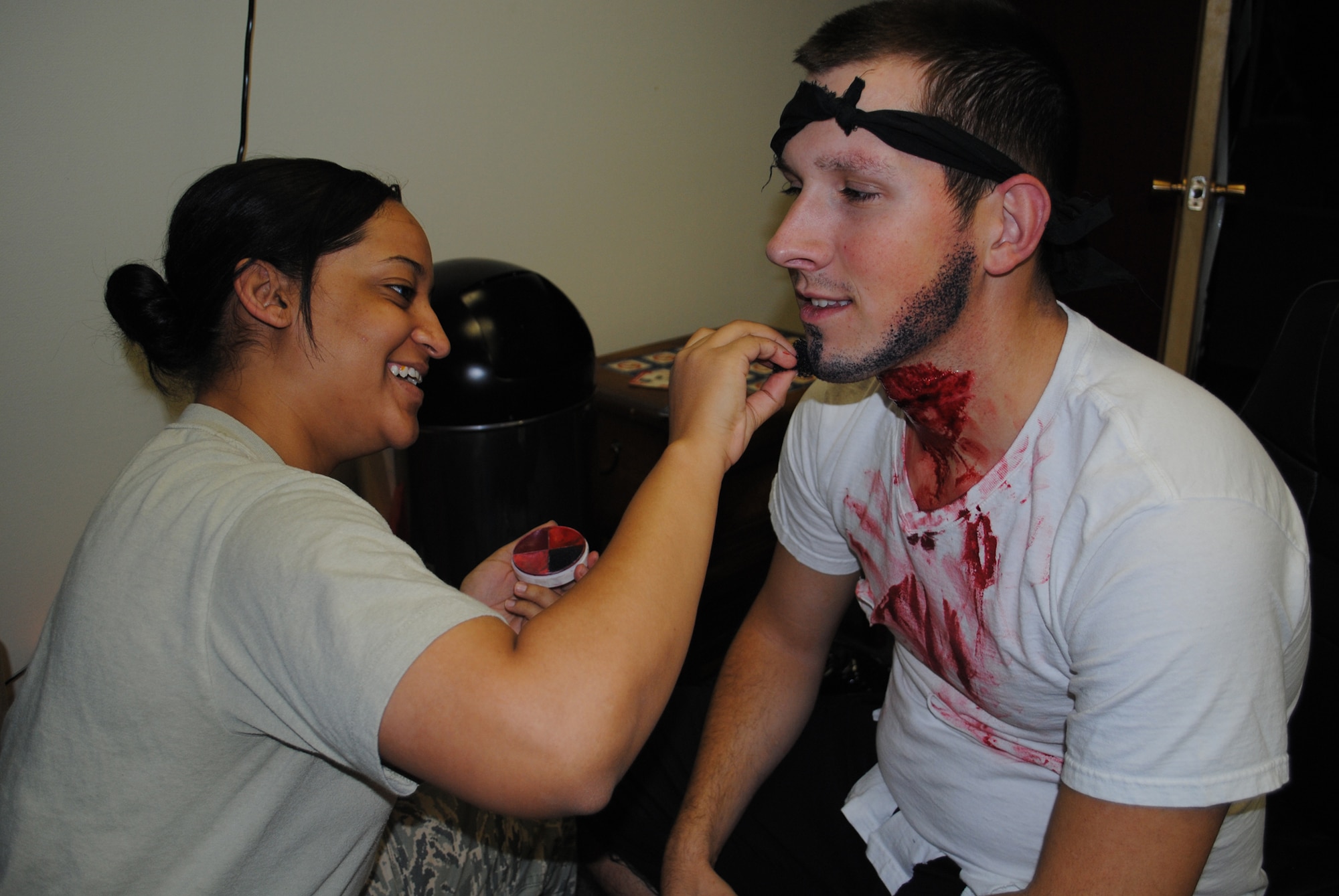 Airman 1st Class Zachary Freeman, 341st Medical Operations Squadron flight medic, gets into character as Senior Airman Katiusca Ogando, 341st MDOS technician, adds some artistic touches to his pirate-themed Halloween costume at the Airman’s Council party Oct. 22.(U.S. Air Force photo/Airman 1st Class Kristina Overton)